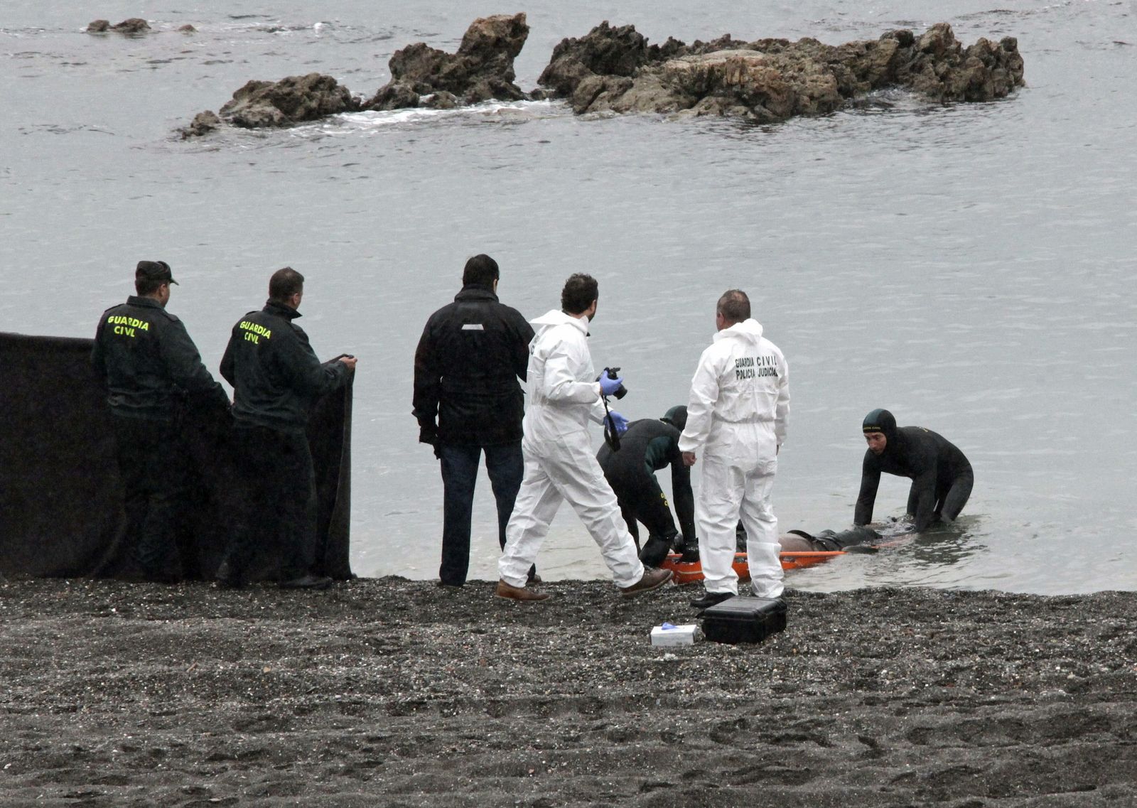 La Guardia Civil rescata en la playa del Tarajal de Ceuta el cadáver de uno de los  15 subsaharianos fallecidos en febrero de 2014 al tratar de llegar a nado a la costa.