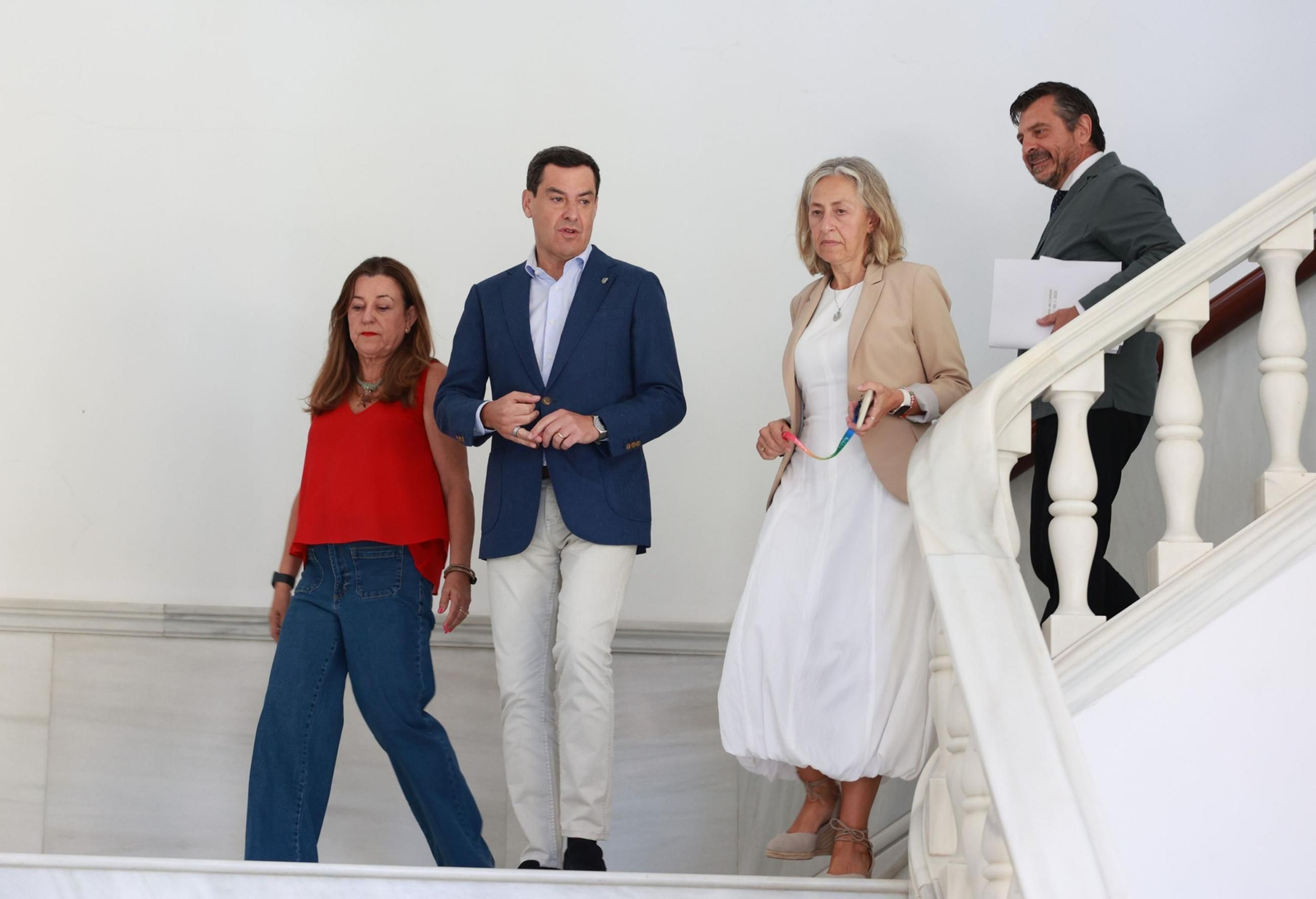Juanma Moreno en las escaleras que conducen al Salón de Plenos junto a las consejeras de Salud, Educación y el portavoz del PP.