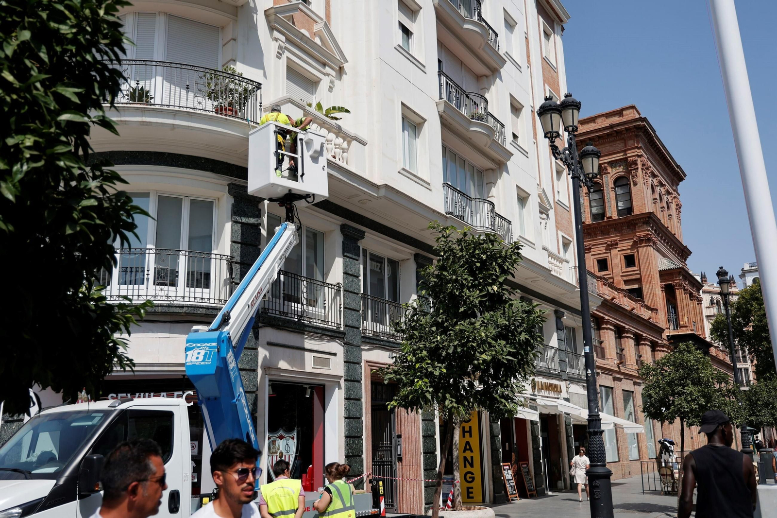 Los operarios colocan los primeros anclajes para los toldos en la Avenida de la Constitución.