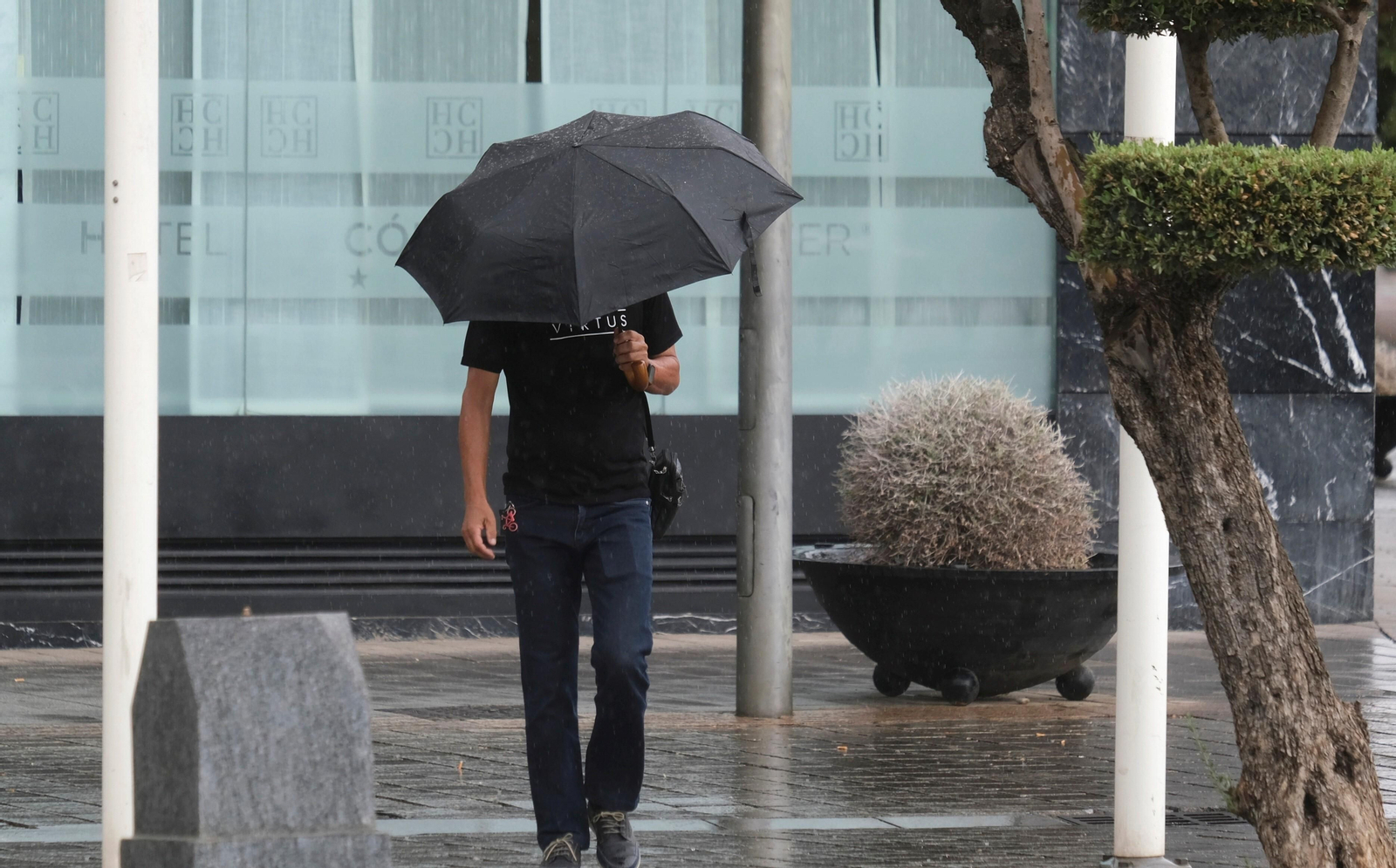 Un hombre se protege de la lluvia en Córdoba.