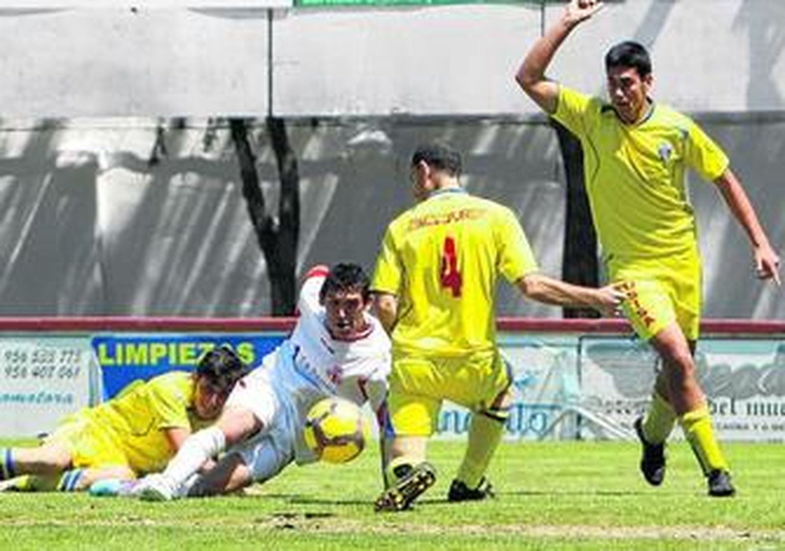 El chiclanero Crespo lucha desde el césped con tres jugadores del Isla Cristina.