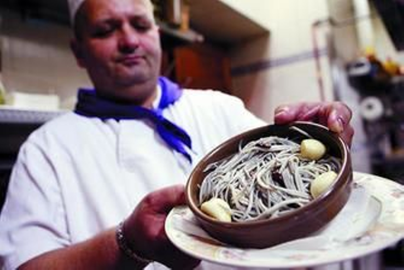 El cocinero del restaurante La Isla muestra una cazuela de angulas.