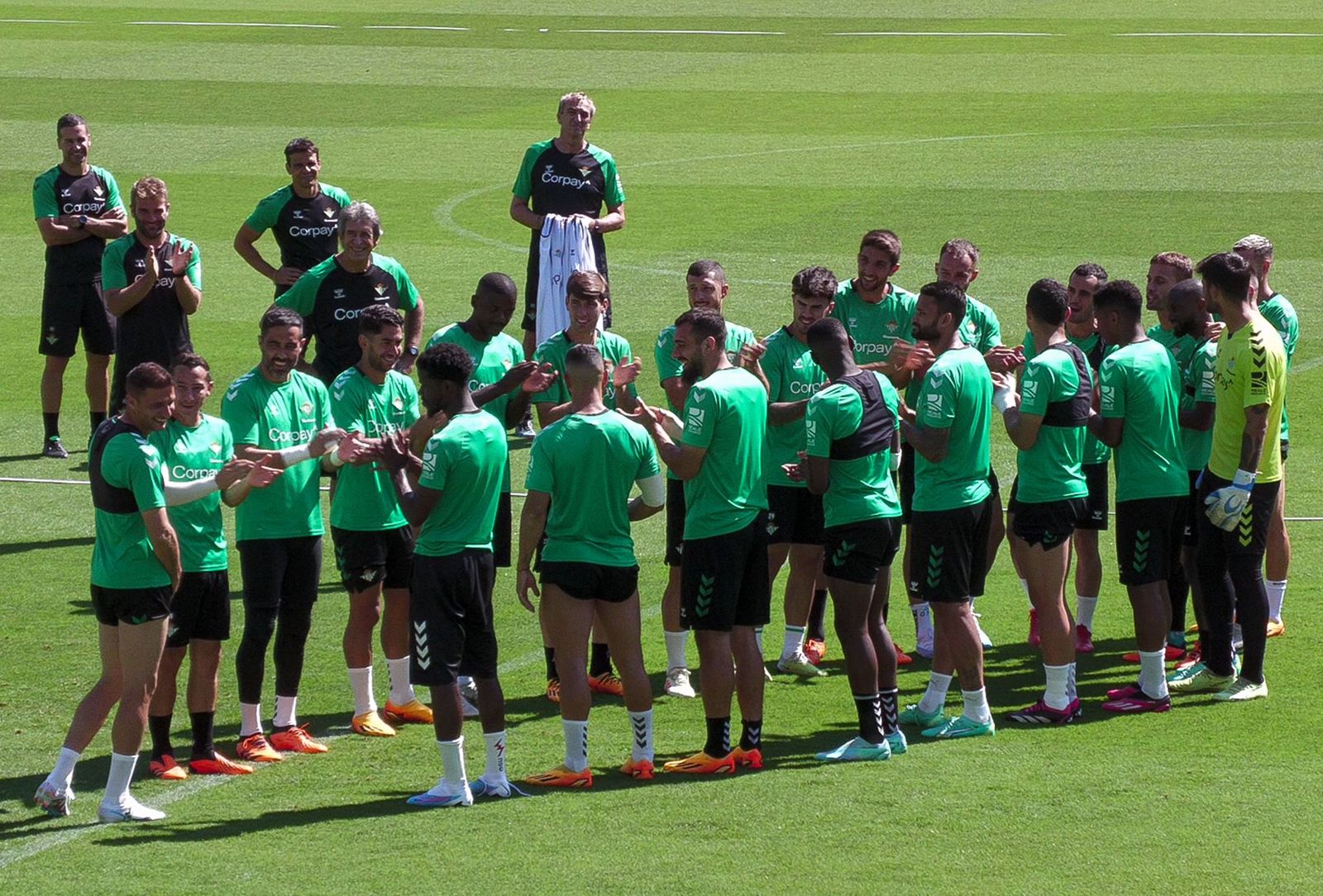 Los jugadores del Betis le hacen el pasillito a su capitán, Joaquín, al inicio del entrenamiento de ayer en el Benito Villamarín.