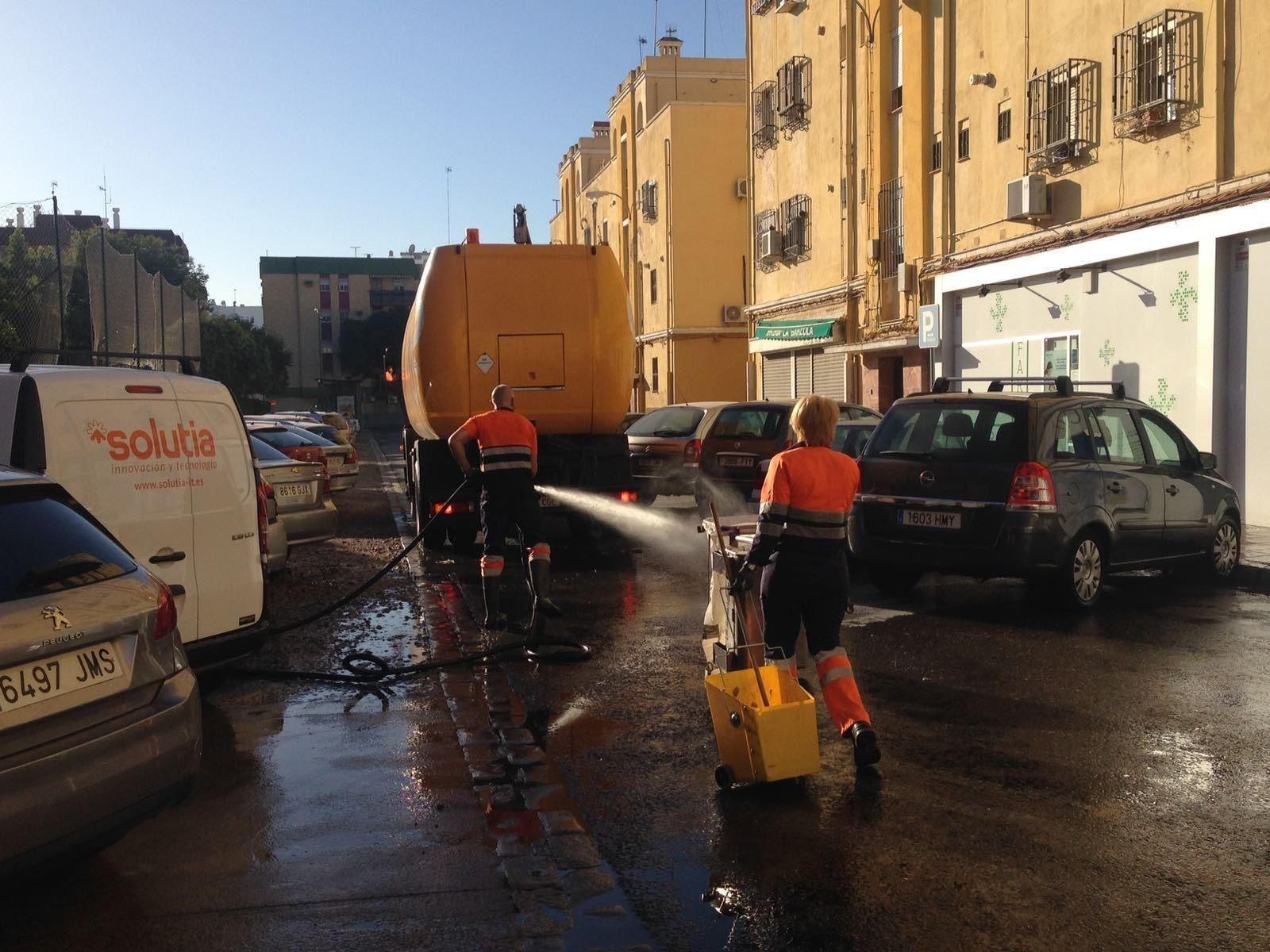 Una pareja de trabajadores de Lipasam limpian una de las calles del barrio de Tartessos.