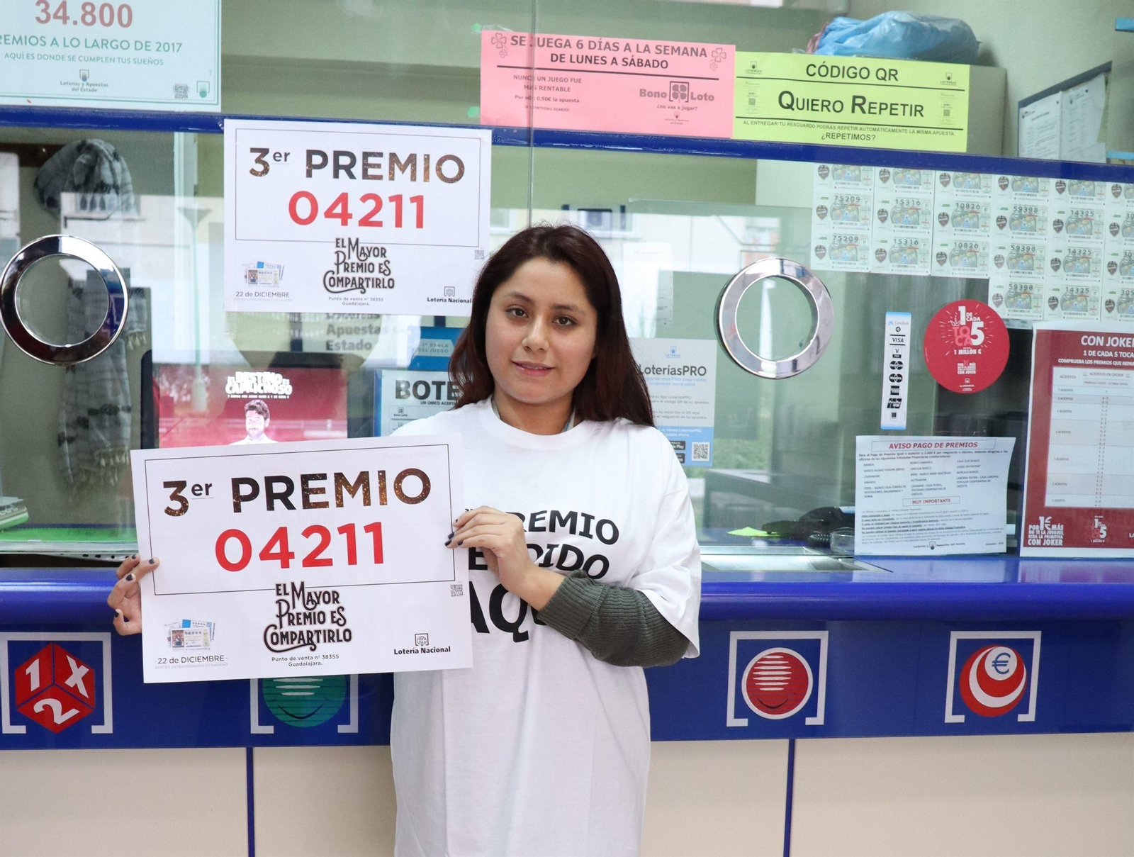 La vendedora de una administración muestra el 04211, tercer premio de la Lotería de Navidad.