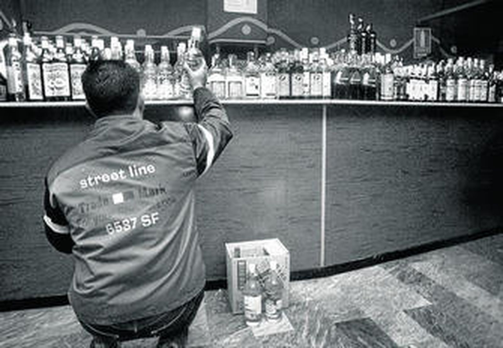 El encargado de un bar repone las bebidas.