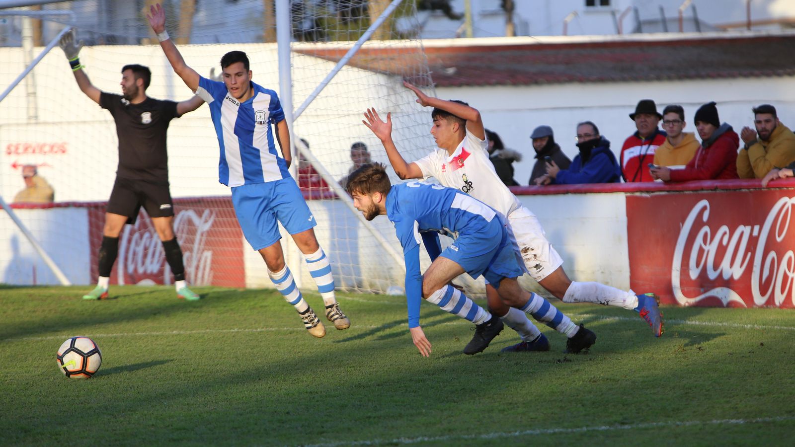 Selu intenta llevarse el balón y Fabio y Maqueira reclaman falta.