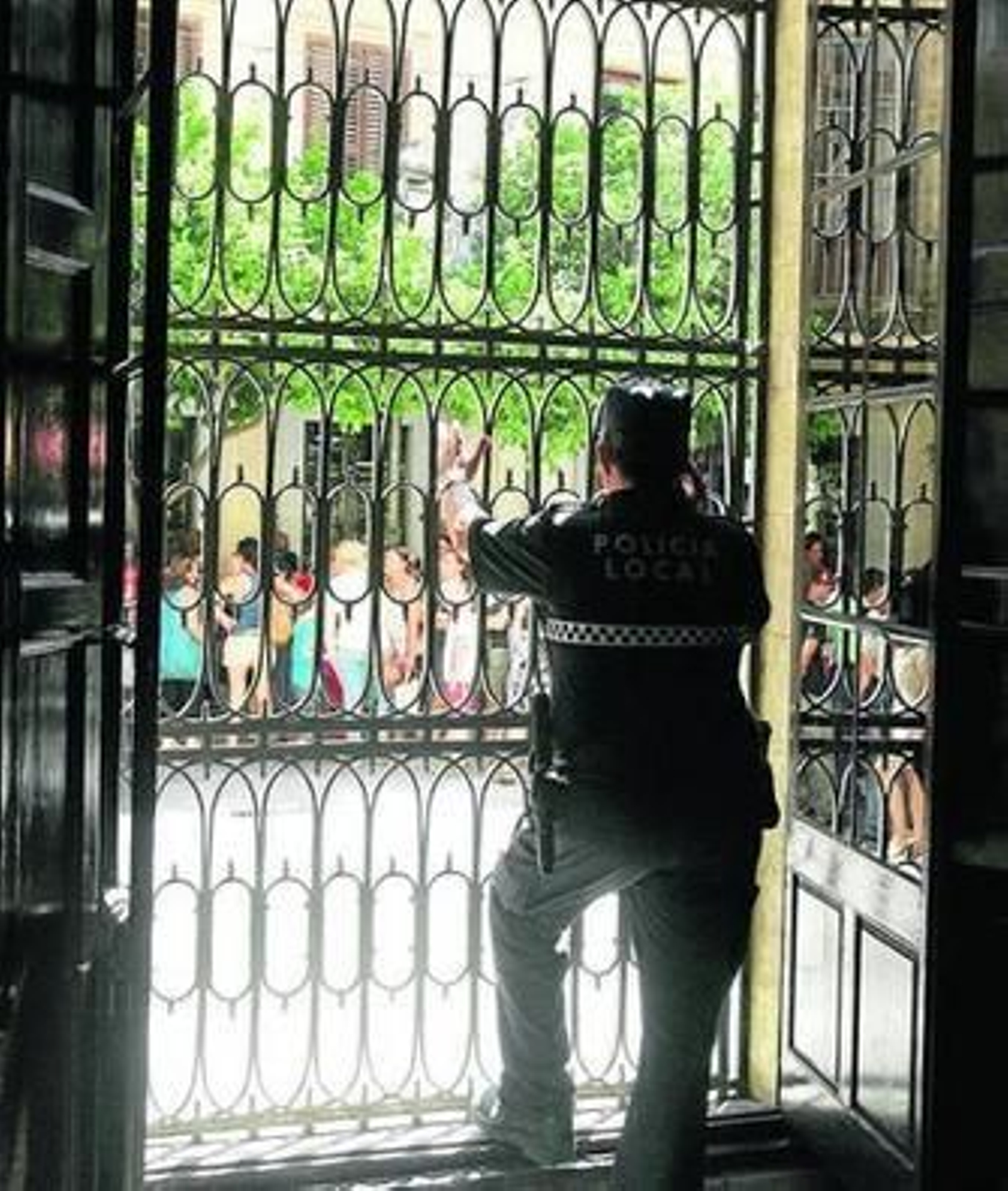 Un agente del 092 observa las protestas del pasado viernes tras uno de los ventanales del Consistorio.