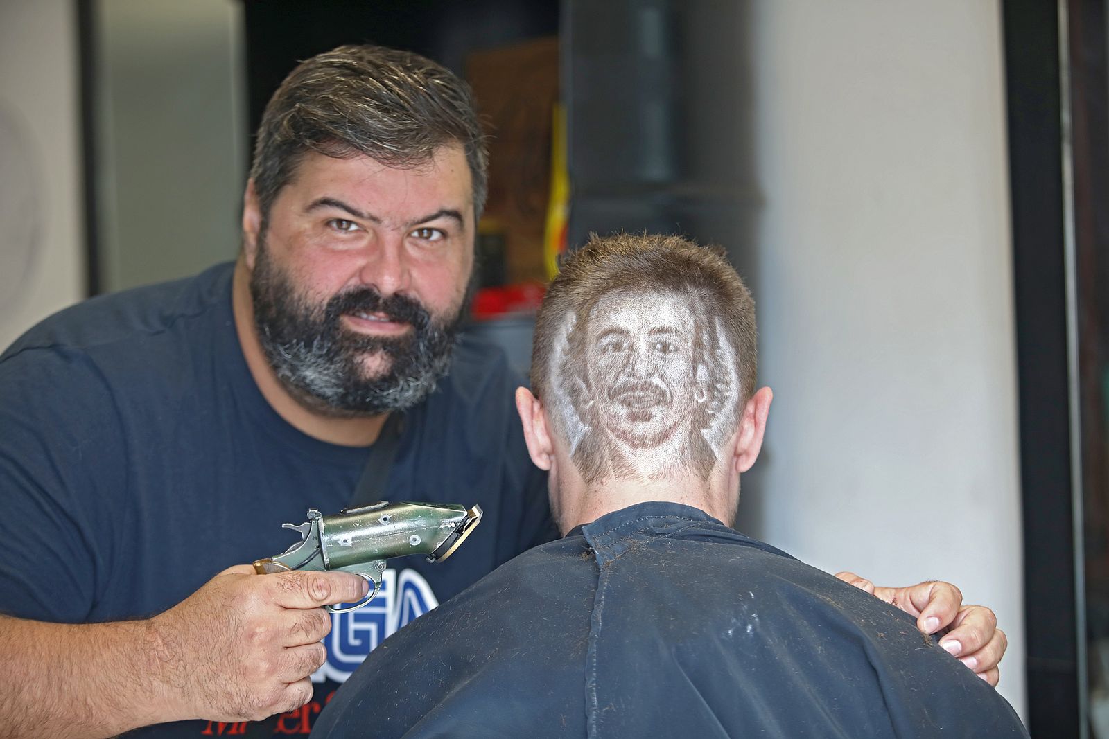 Iván Fernández tras realizar la cara de 'Kichi' en el cogote de un cliente.