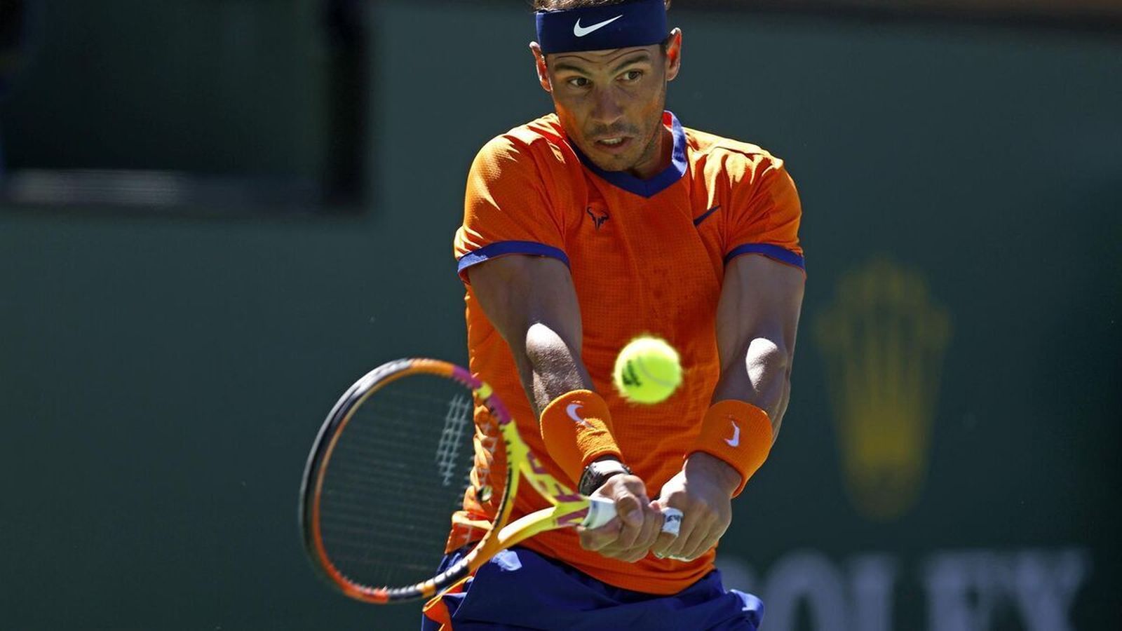 Nadal golpea dolorido una pelota.
