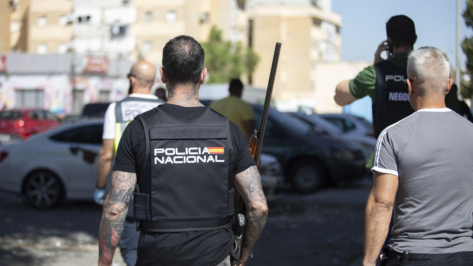 Policías judiciales con el arma encontrada en la vivienda.