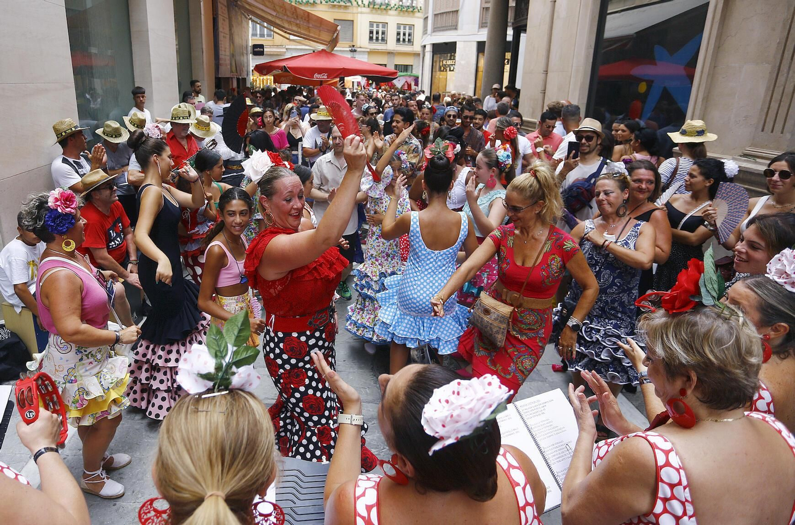 Numerosas personas bailan este sábado en el centro de Málaga, en el arranque de la Feria.
