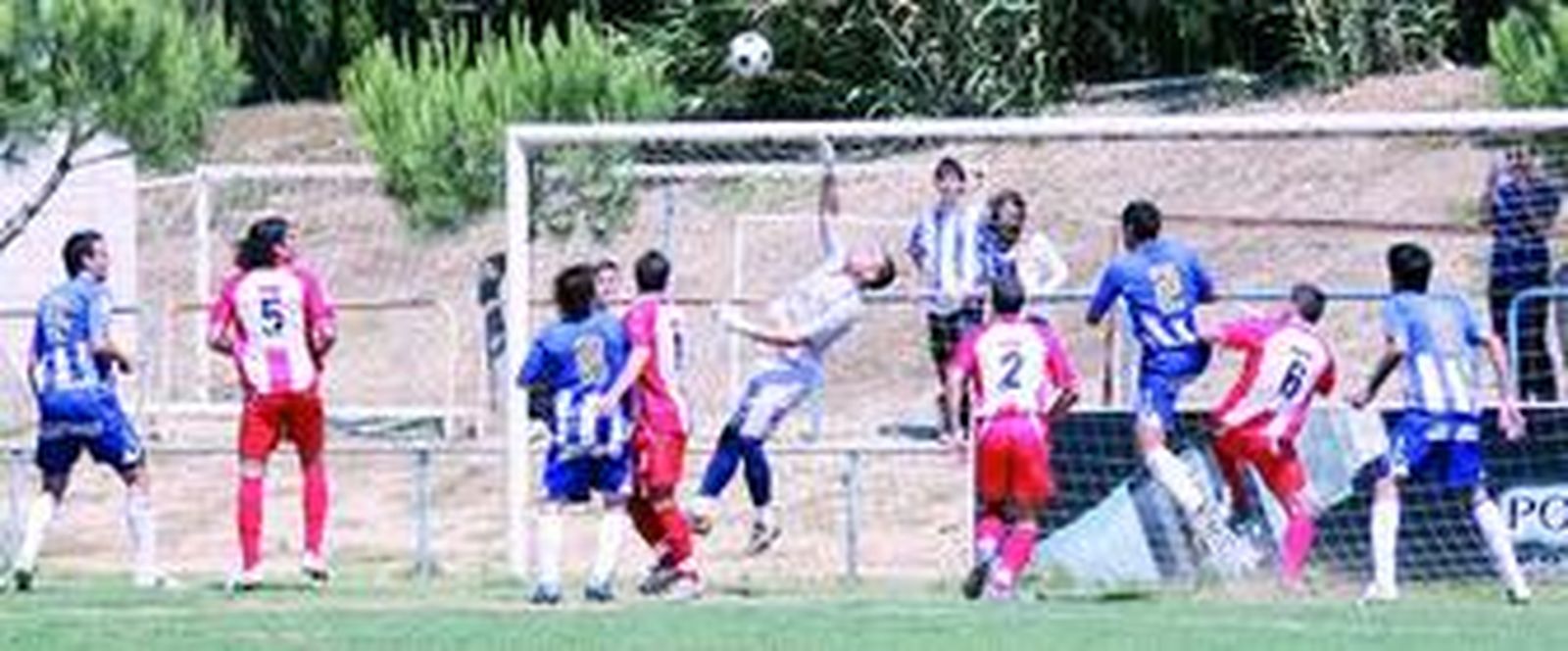 El guardameta almeriense Álvaro intenta despejar un balón colgado por el Málaga al corazón del área visitante.