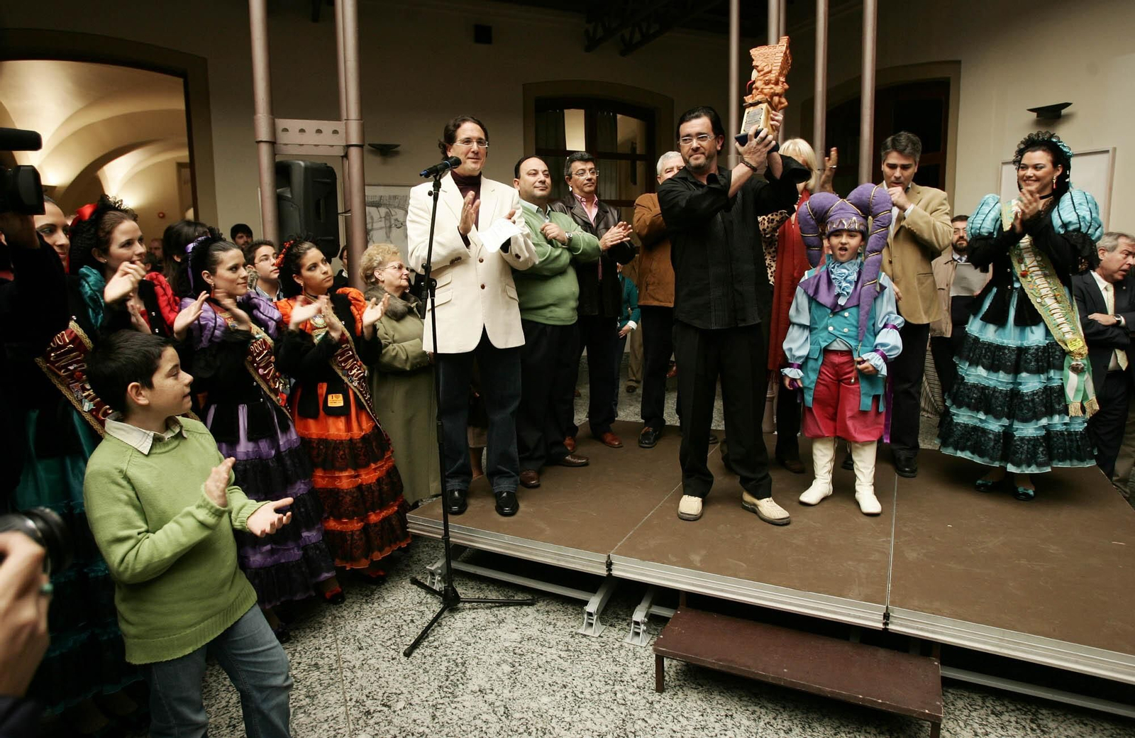 Juan Carlos Aragón recibe el trofeo que acredita a su comparsa como ganadora de la modalidad.