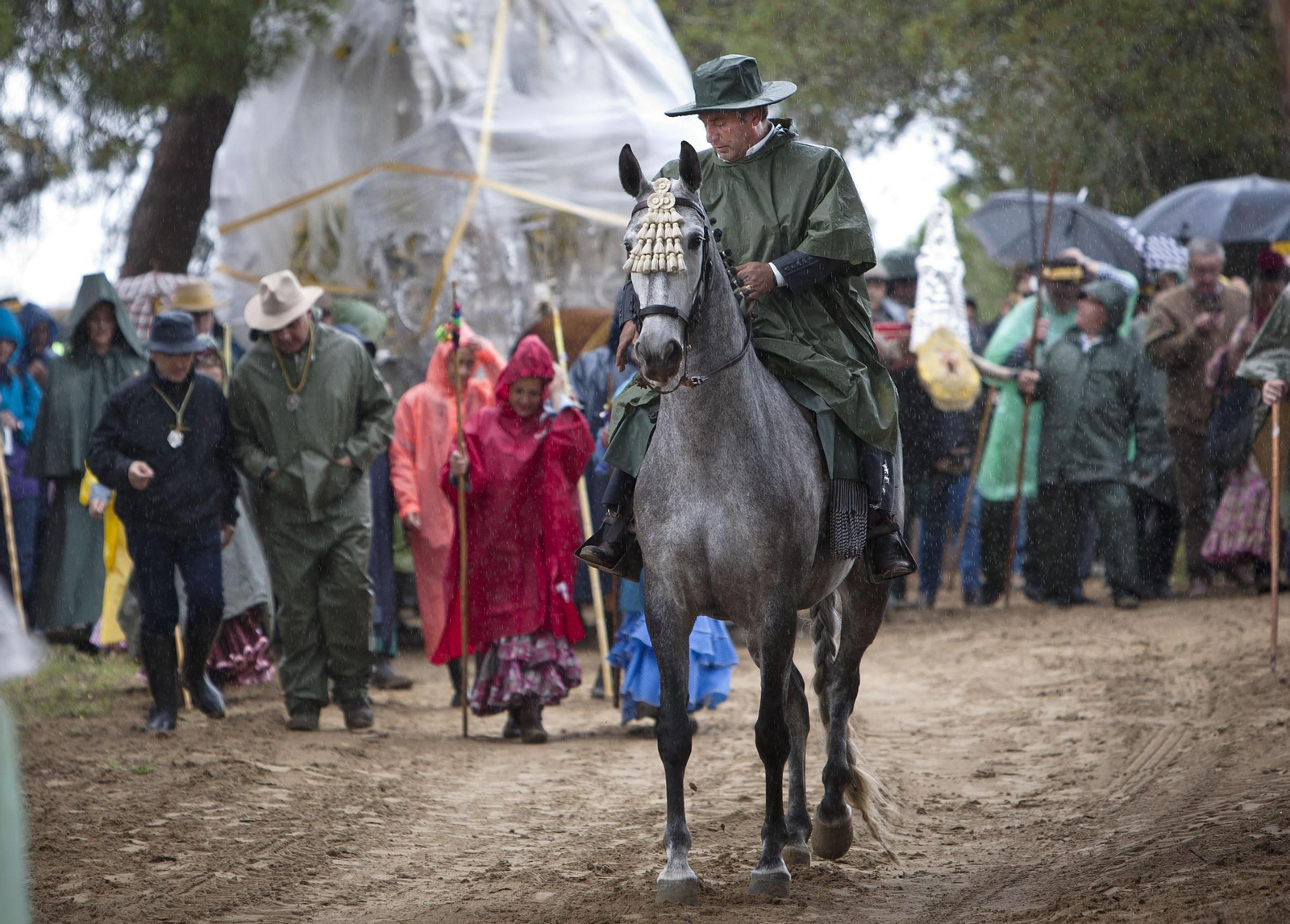 Los peregrinos, equipados para la lluvia, cruzando hacia el Coto en la romería del año pasado.