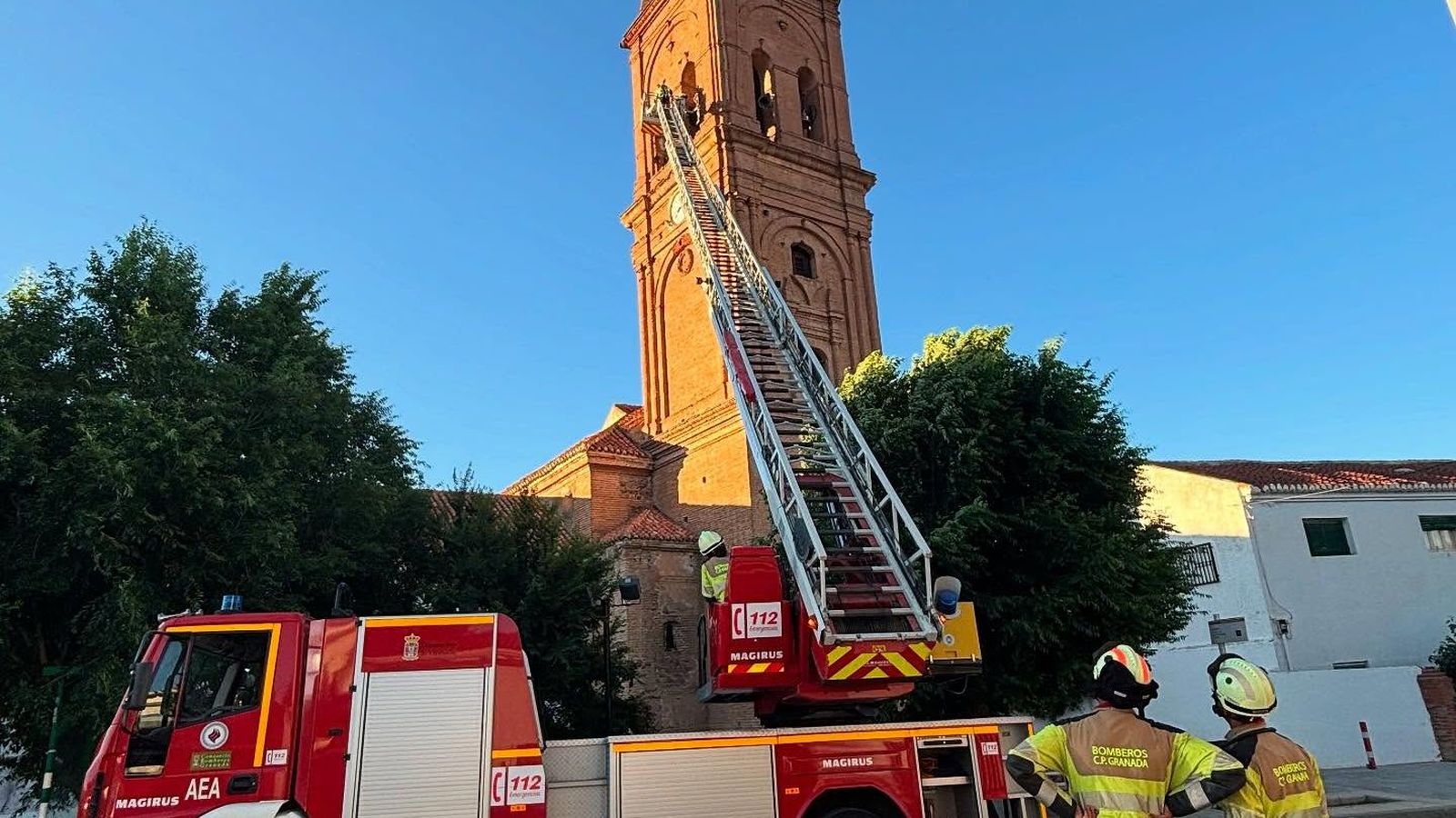 Los bomberos observan la campana en lo alto de la torre