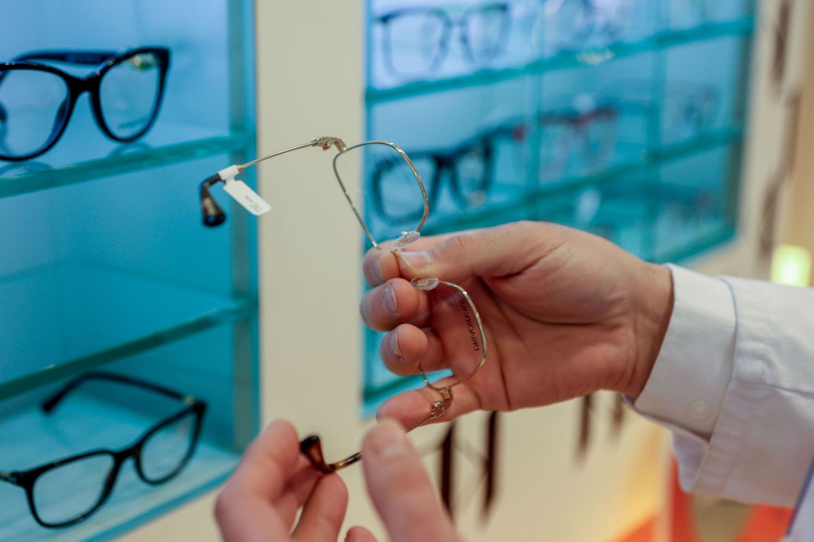 Un profesional muestra unas gafas en una óptica.