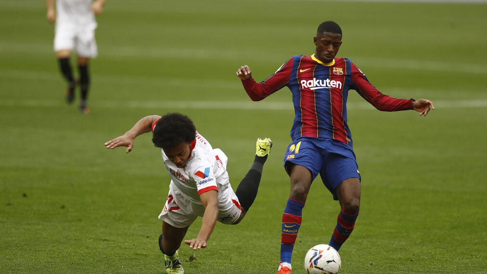 Koundé se va al suelo ante Dembélé en la primera parte.