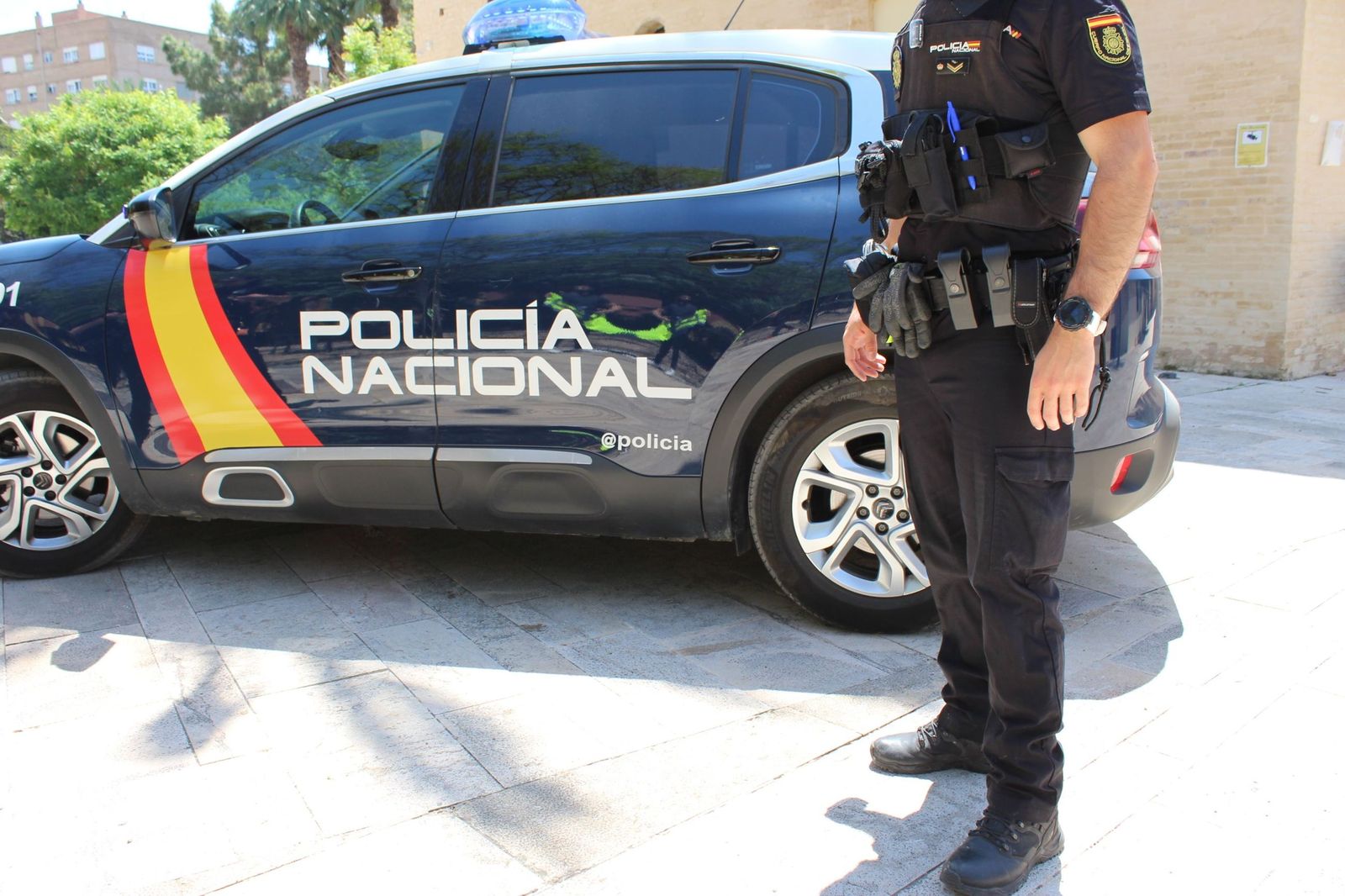 Imagen de archivo de un agente frente a un coche de la Policía Nacional.