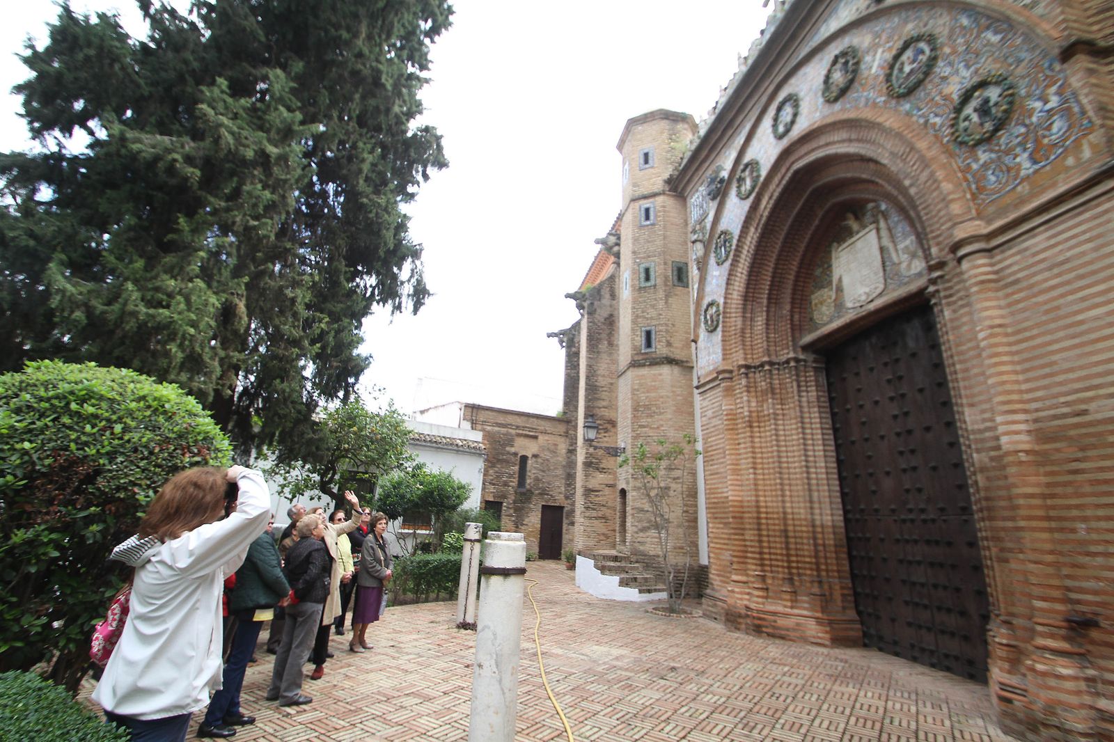 Los turistas fotografían el pórtico de Santa Paula, con sus característicos tondos cerámicos.