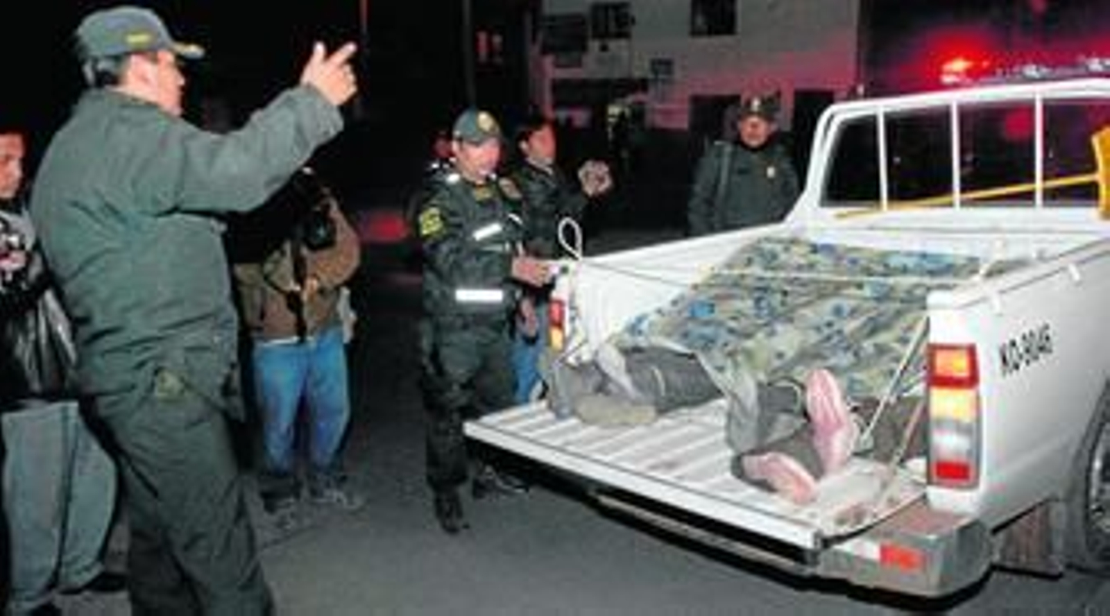 Una camioneta donde se apilan los cuatro fallecidos junto a tres de los heridos.
