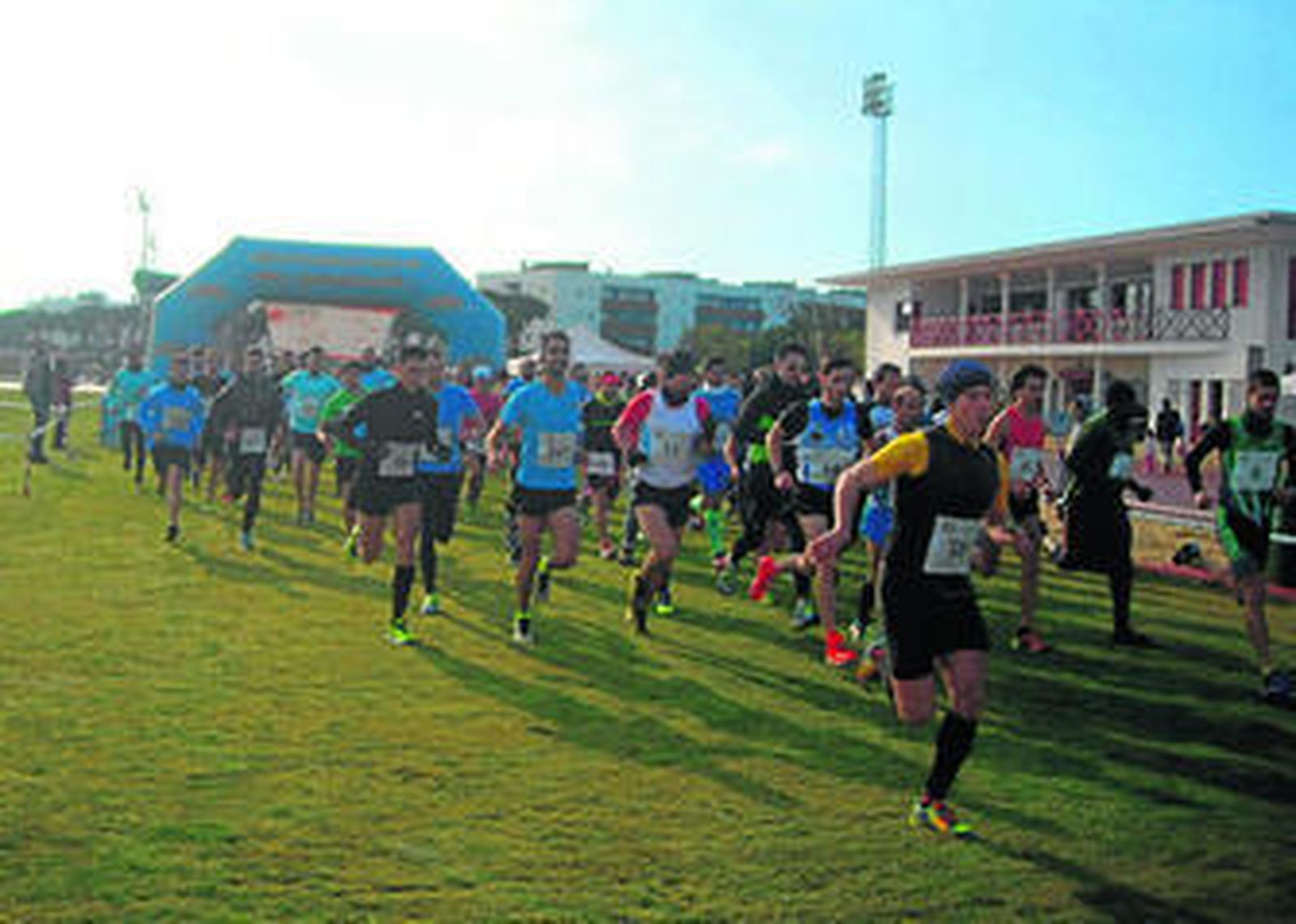 Un momento de la prueba en la categoría absoluta celebrada ayer en Punta Umbría; a la derecha, los ganadores, Ali El Fghir y Sara Caballero, posan con sus trofeos.