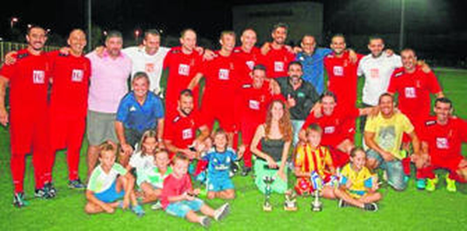 Los campeones posan junto a familiares con los trofeos conquistados.