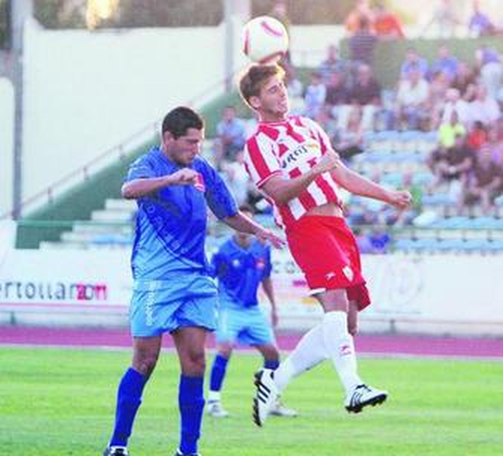 Luque lucha un balón aéreo con un contrario.