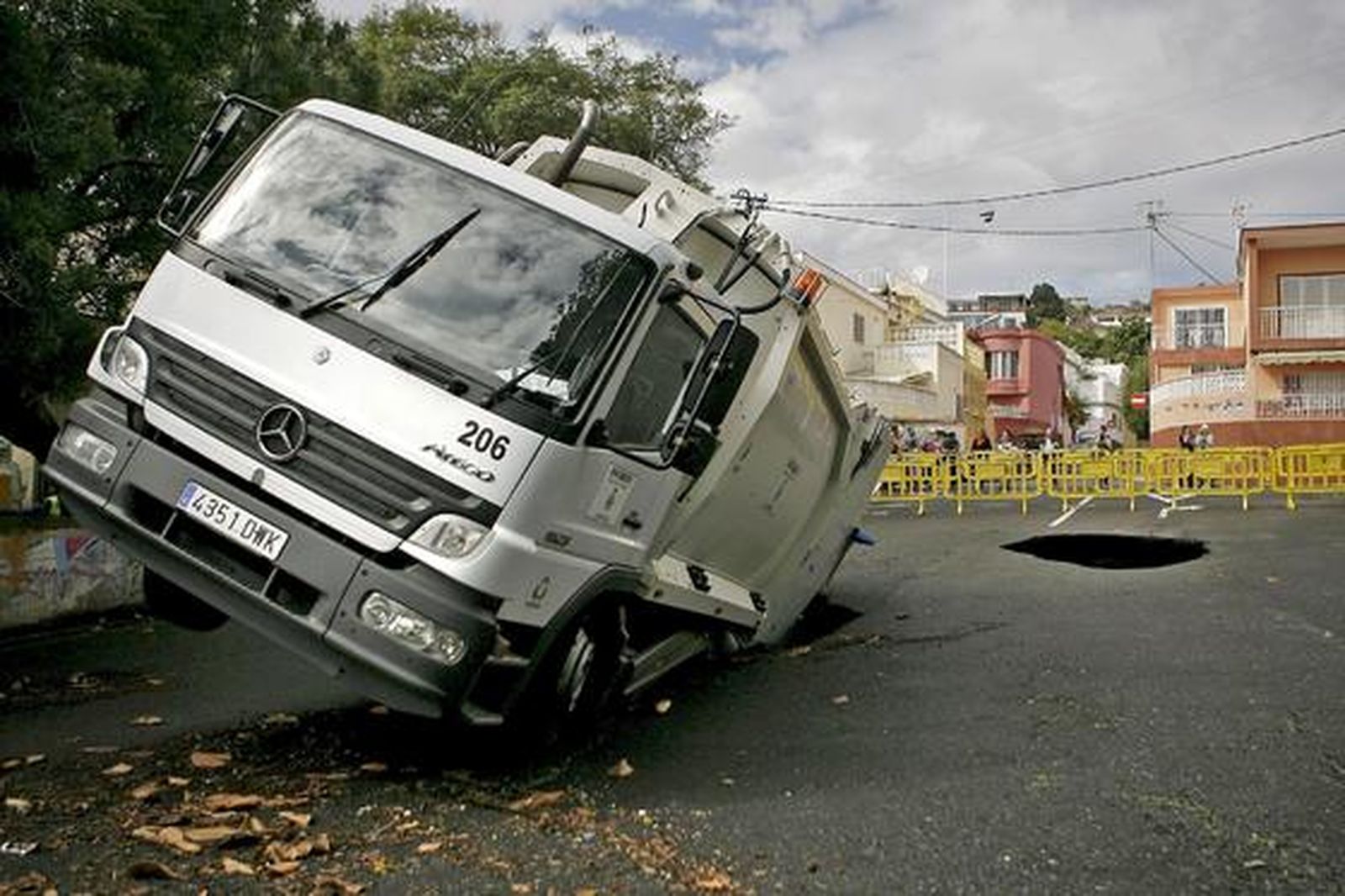 Un camión de recogida de basura atrapado en uno de los boquetes ocasionados por las fuertes lluvias caídas en Tenerife. 

Foto: Cristóbal García (Efe)
