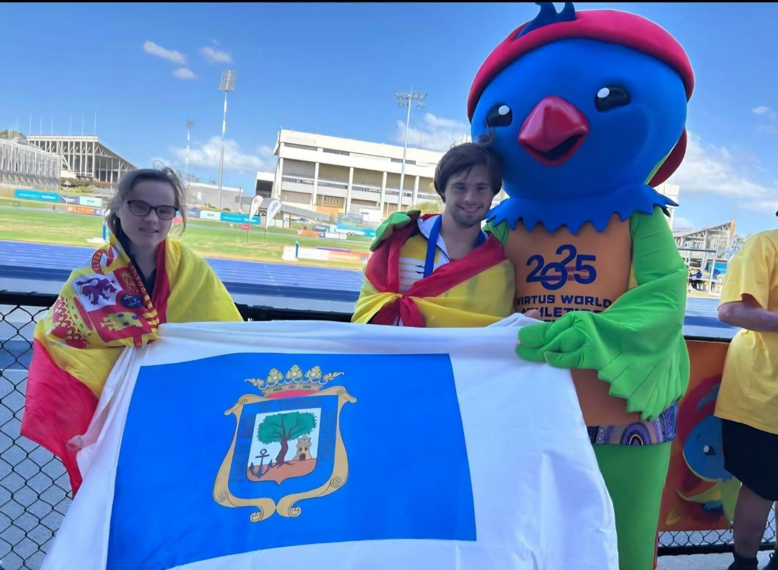 Blanca Betanzos y Nicolás Castaño posan con la bandera de Huelva.