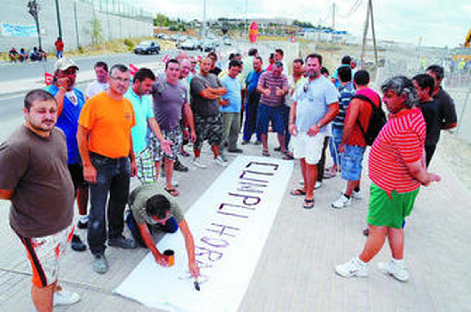 Los manifestantes preparando las pancartas, ayer en los alrededores de la obra.