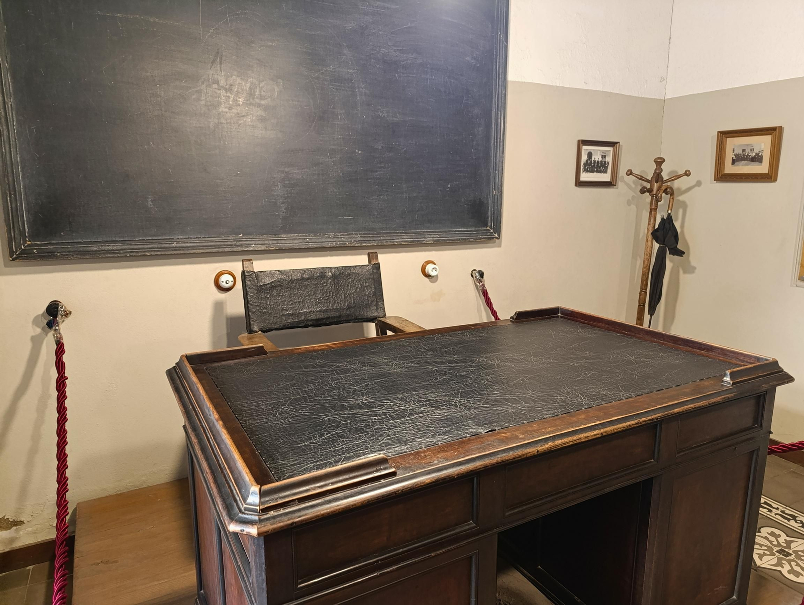 La mesa del profesor y la pizarra original del aula, núcleo simbólico del espacio donde Machado desarrolló su labor docente.