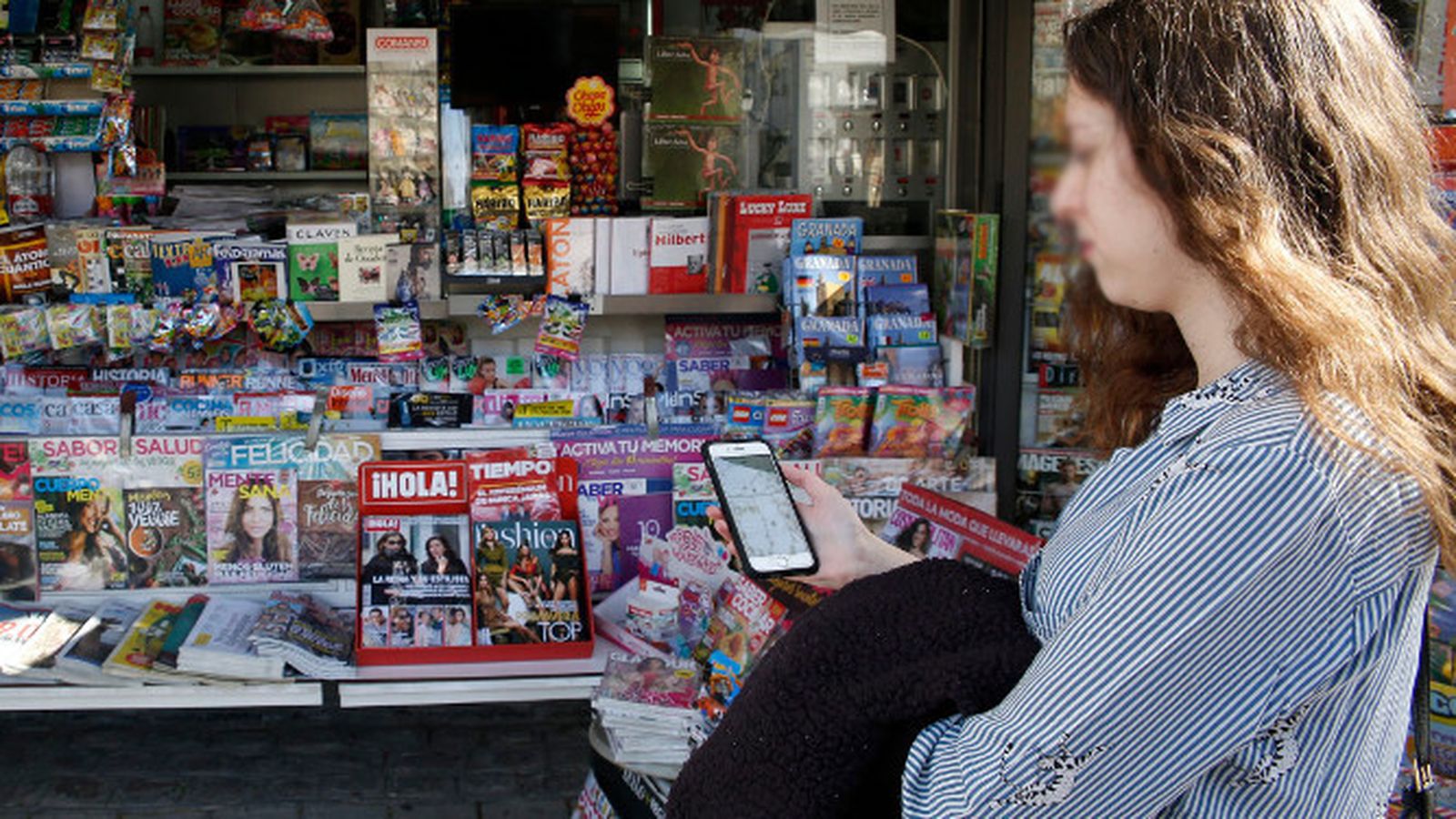 Una joven conectada a una red wifi abierta.