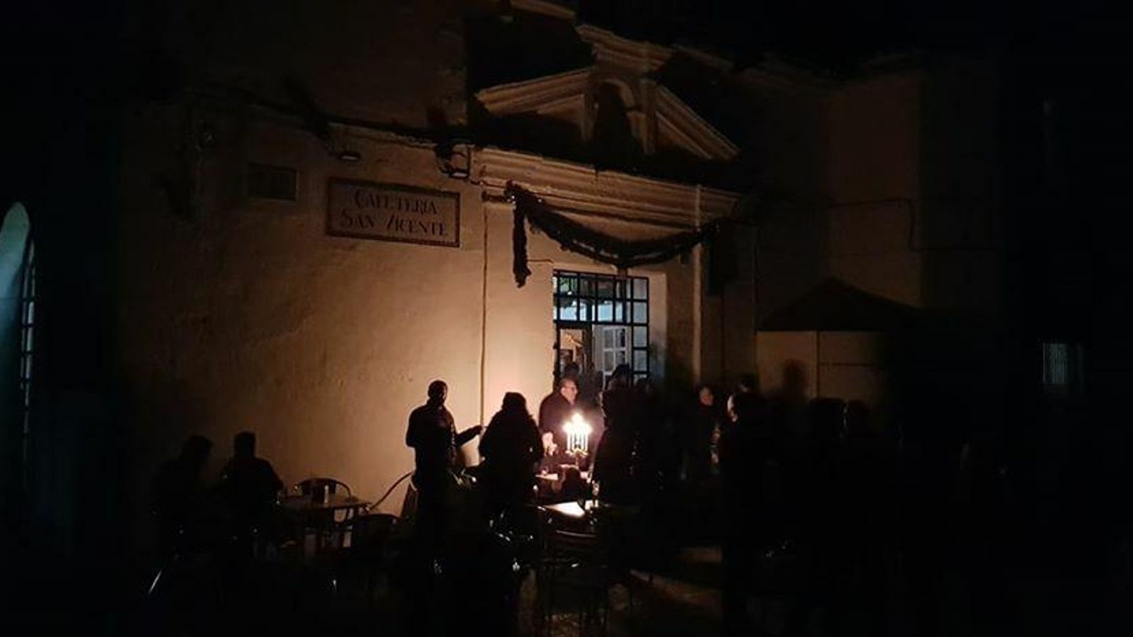 Vecinos alumbrándose con un candelabro, el domingo, mientras esperaban la cabalgata en Guadalcanal.