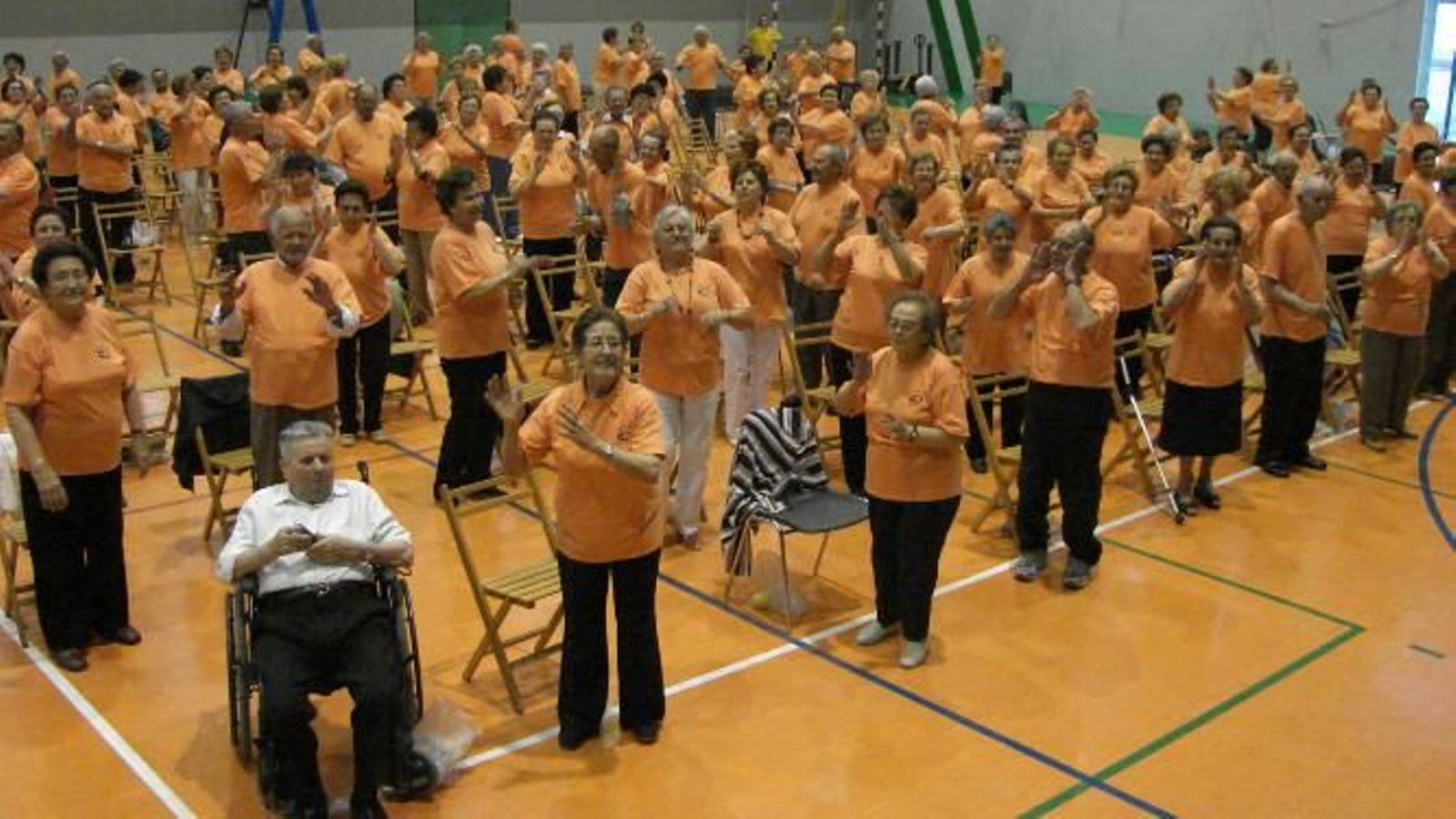Un grupo de ancianos se ejercita en unas instalaciones deportivas.