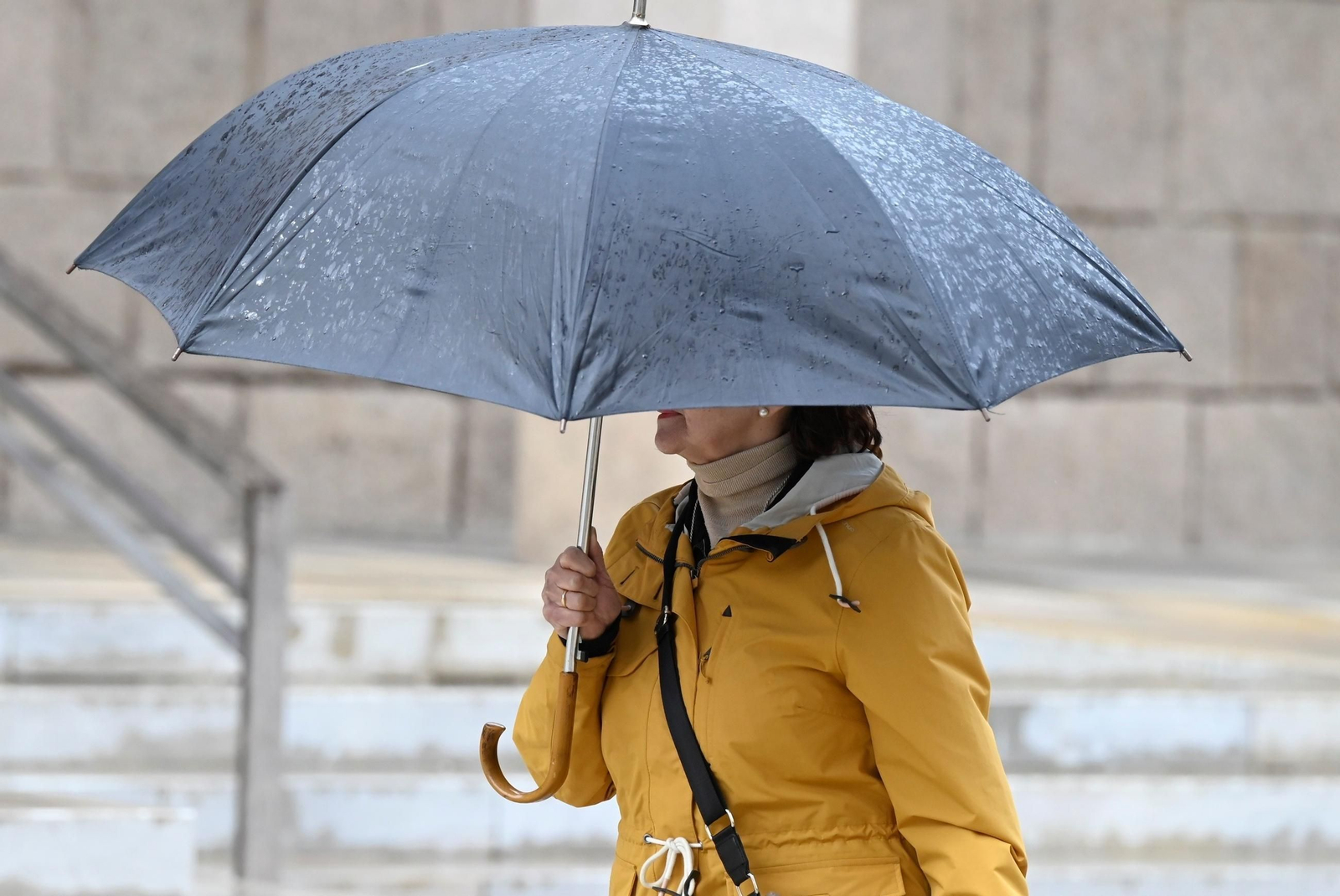 Una persona se protege de la lluvia en Córdoba.