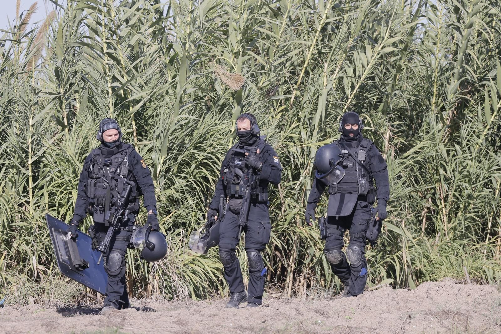 Tres miembros de los GEO, pertrechados de arriba abajo, durante el dispositivo policial desplegado el sábado en Isla Mayor.