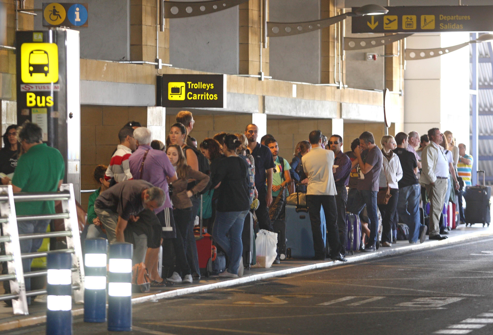 Gente esperando en la parada del autobús del aeropuerto.