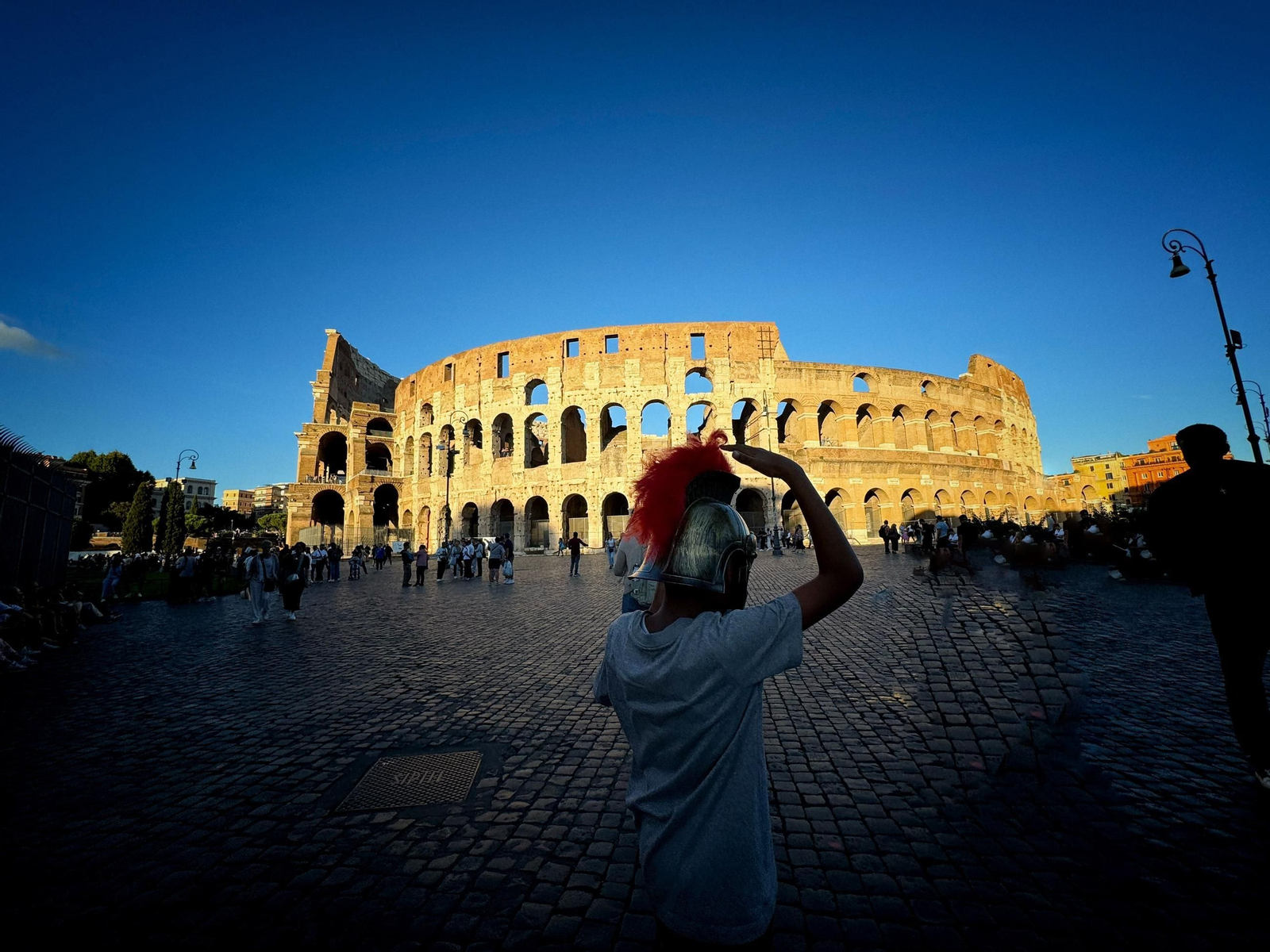 Niño con casco romano a las puertas del Coliseo.