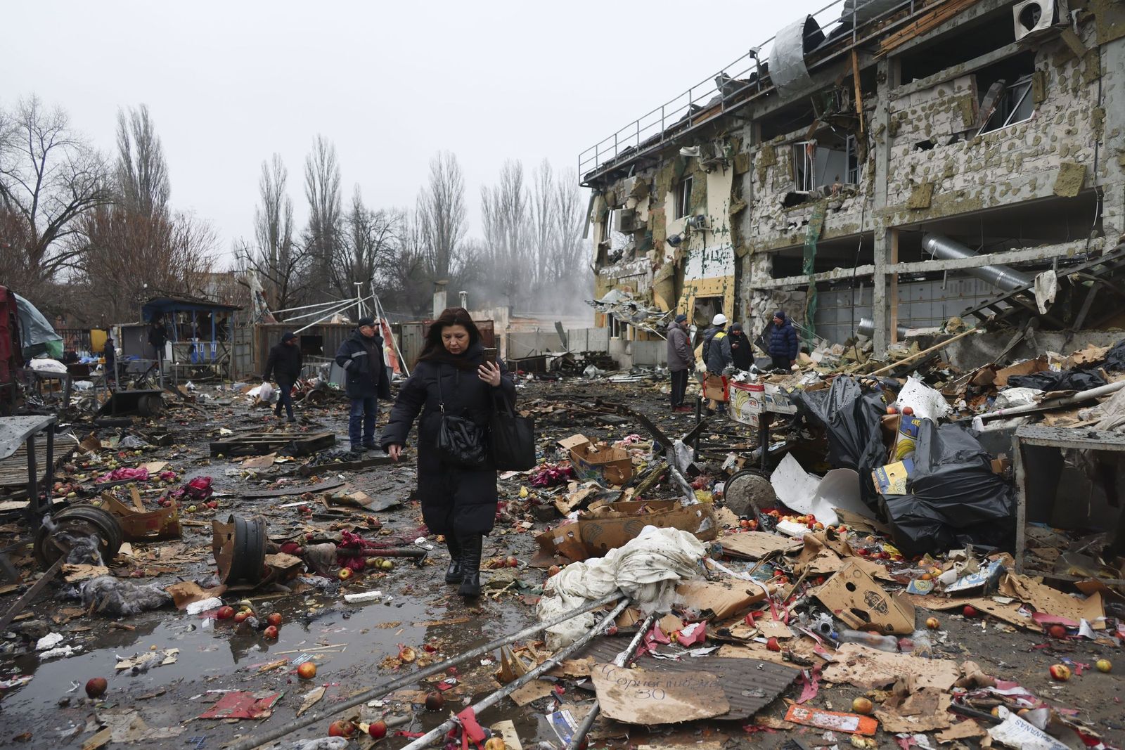 Una mujer pasa ante un edificio bombardeado durante la noche en Odesa.