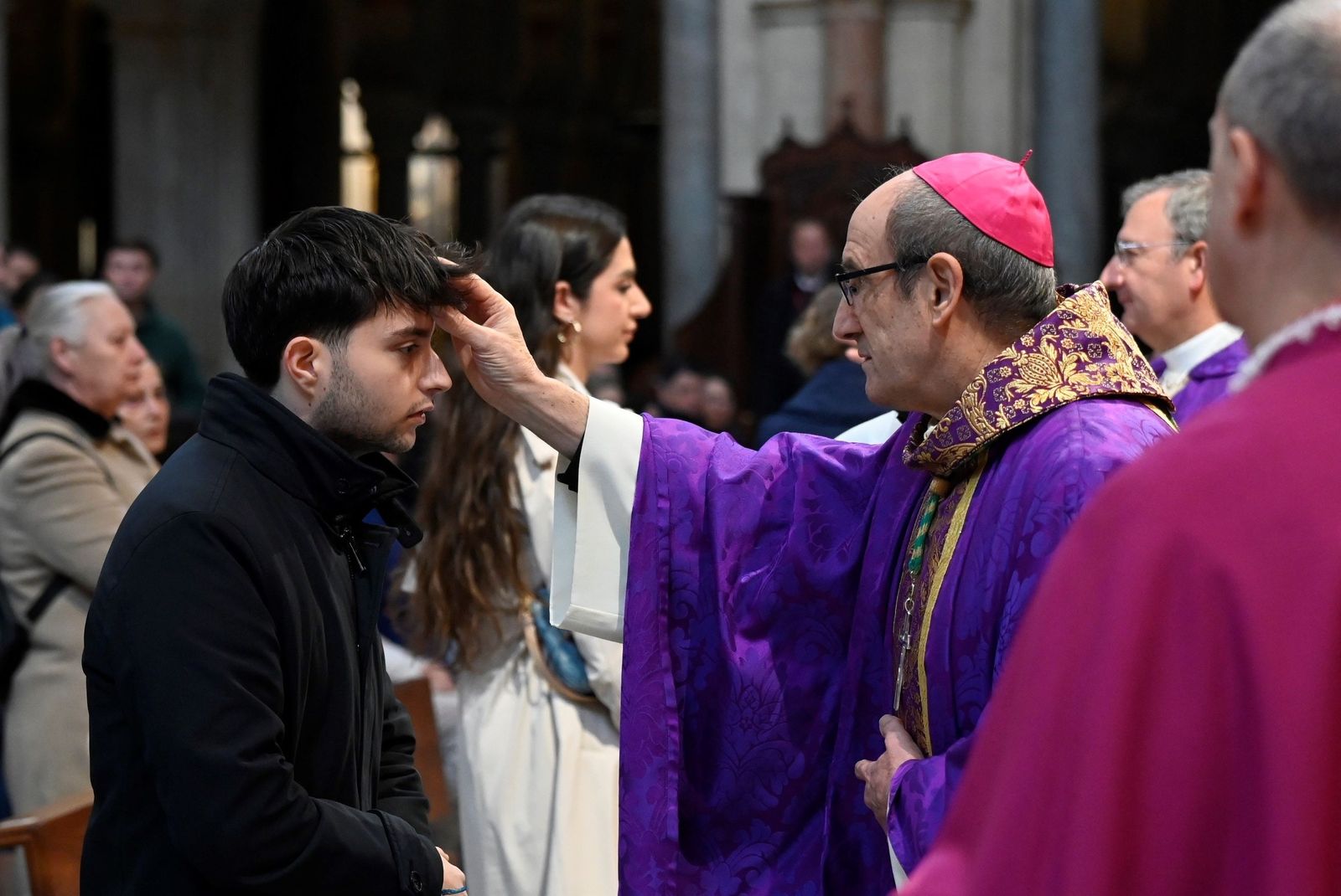 El obispo impone la ceniza a un joven en la Catedral.