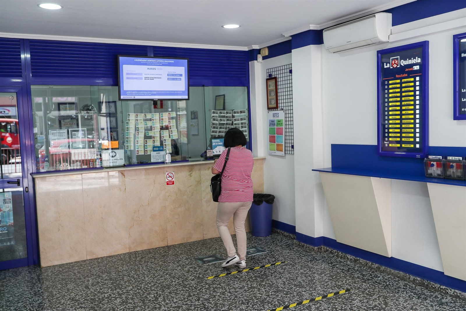 Una mujer compra lotería en una Administración