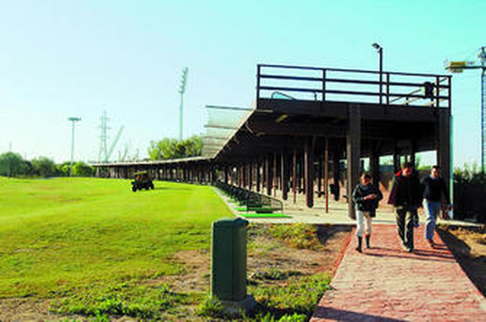 Varias personas salen del 'tee', la zona del campo de golf donde se practican los golpes de salida.