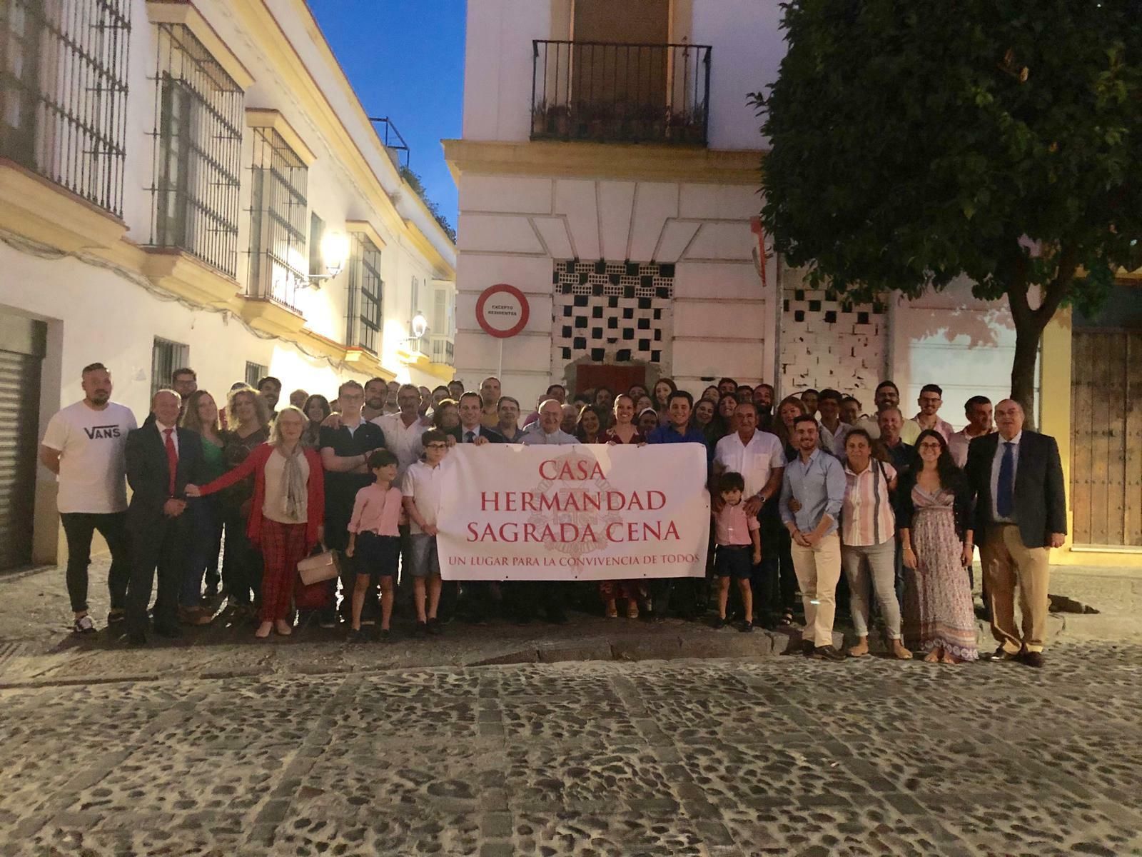 Un grupo de hermanos de la Sagrada Cena junto al local comprado.