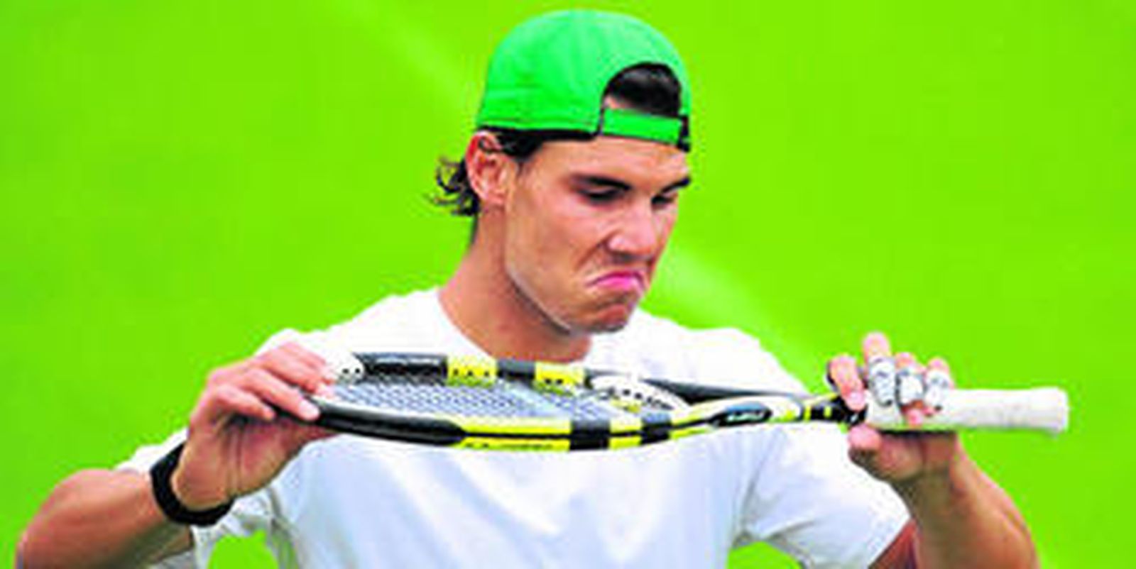 Nadal examina su raqueta durante el entrenamiento de ayer en el All England Tennis Club.
