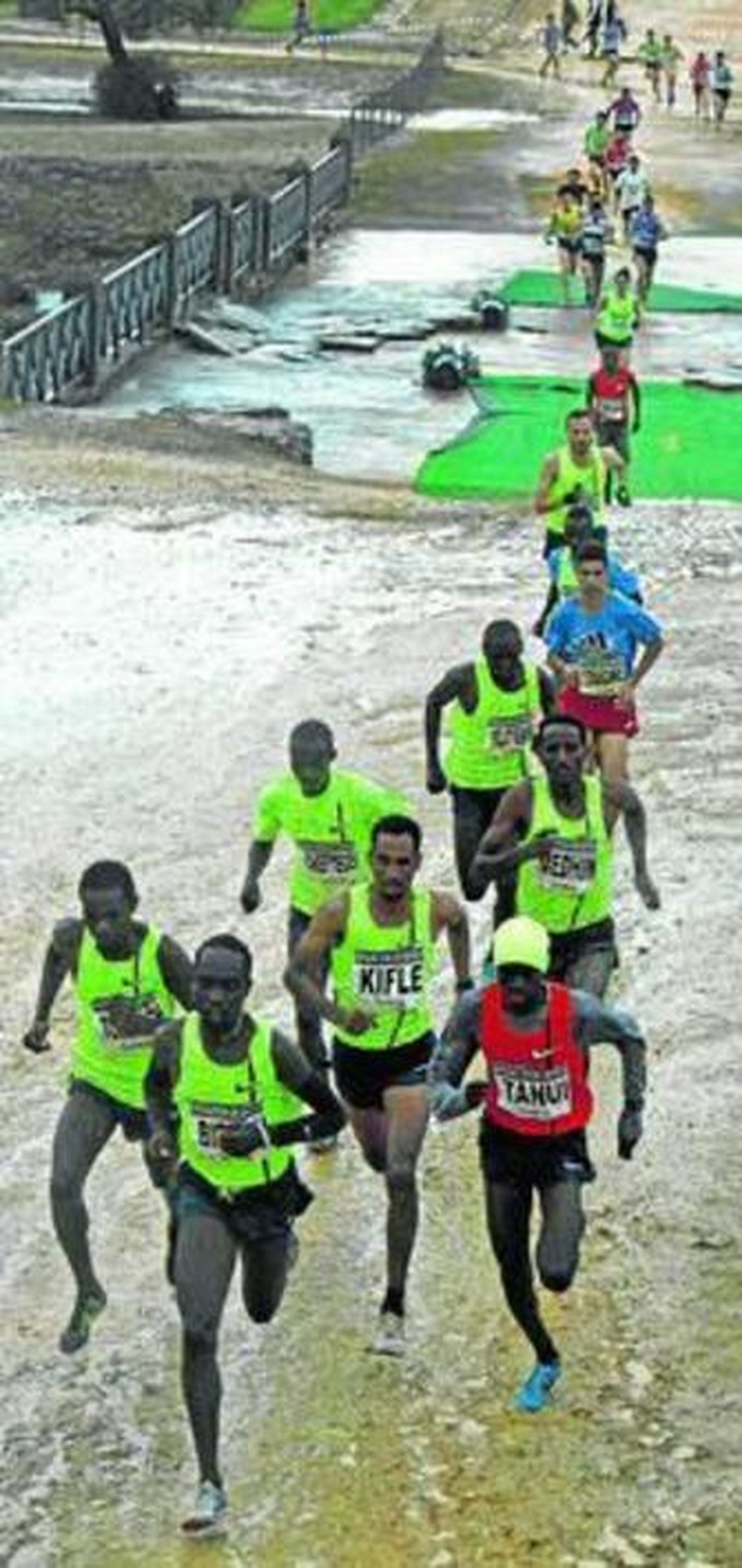El keniano Birech lidera el grupo al paso por un gran charco al inicio de la carrera internacional masculina.