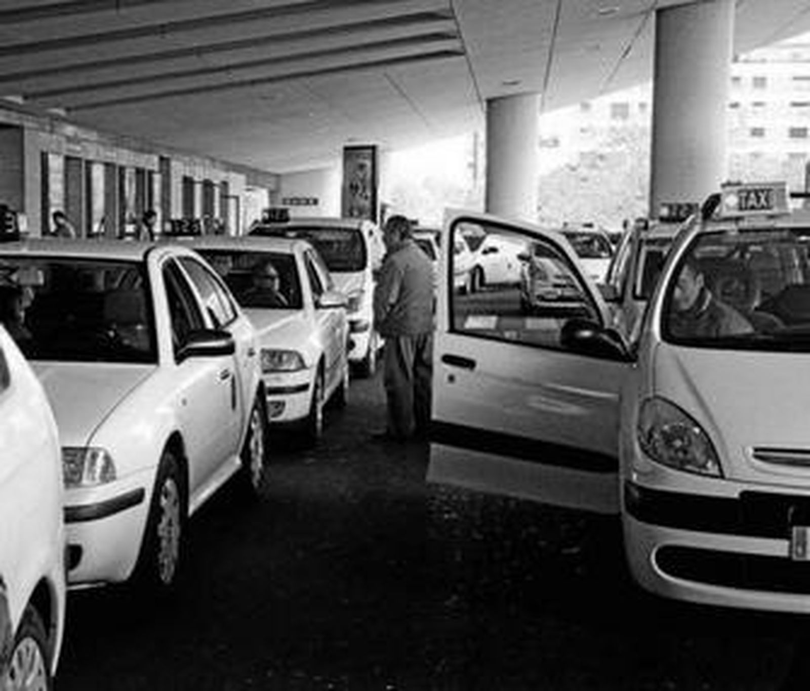 Un grupo de taxistas esperan clientes en la parada de la estación de Santa Justa de Sevilla.