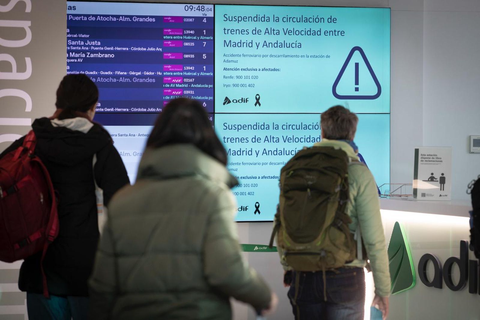 Pasajeros en la estación de Granada miran las pantallas, en las que se avisa de la situación