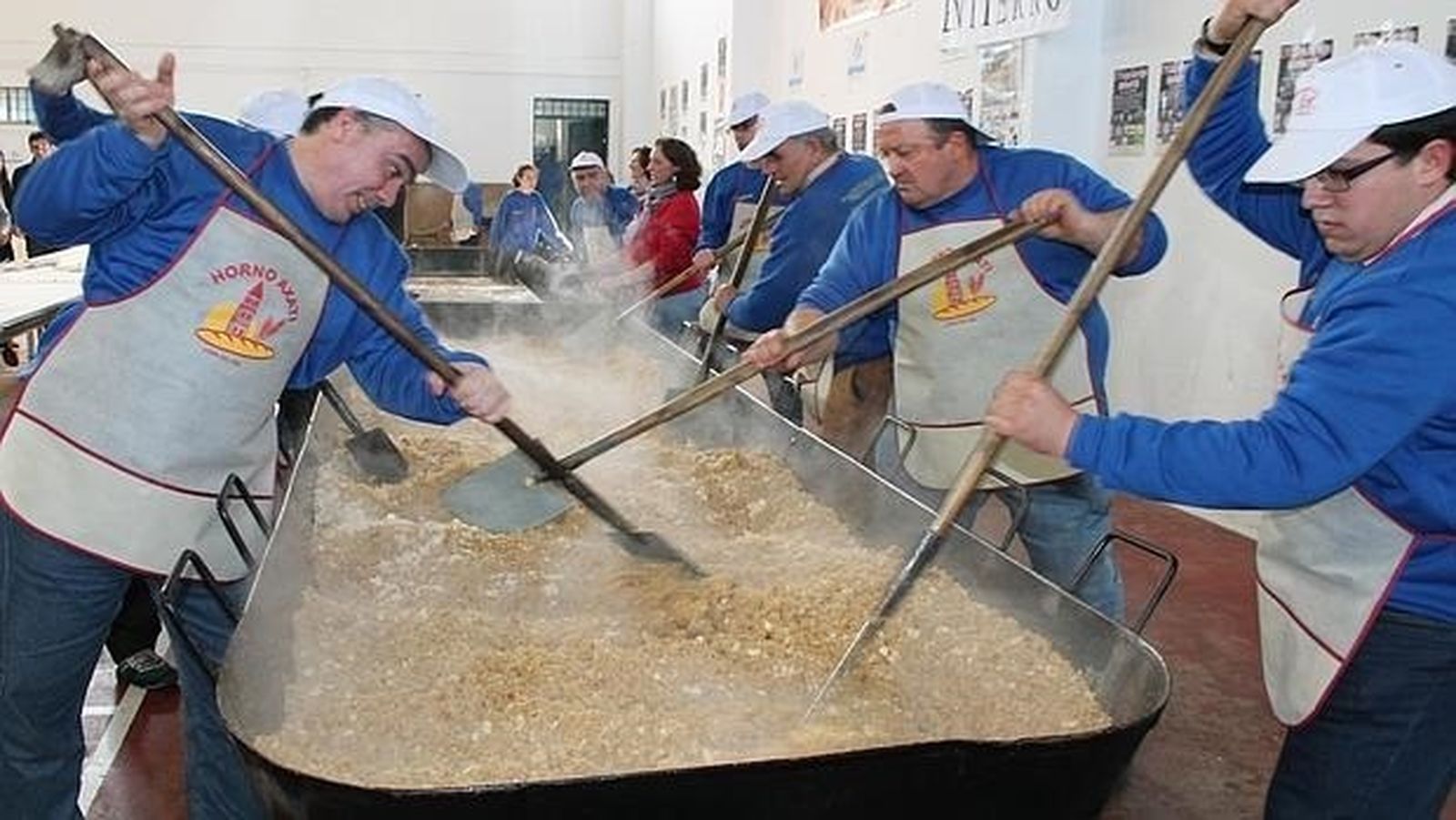 Voluntarios preparan migas en un evento solidario en Lora del Río.