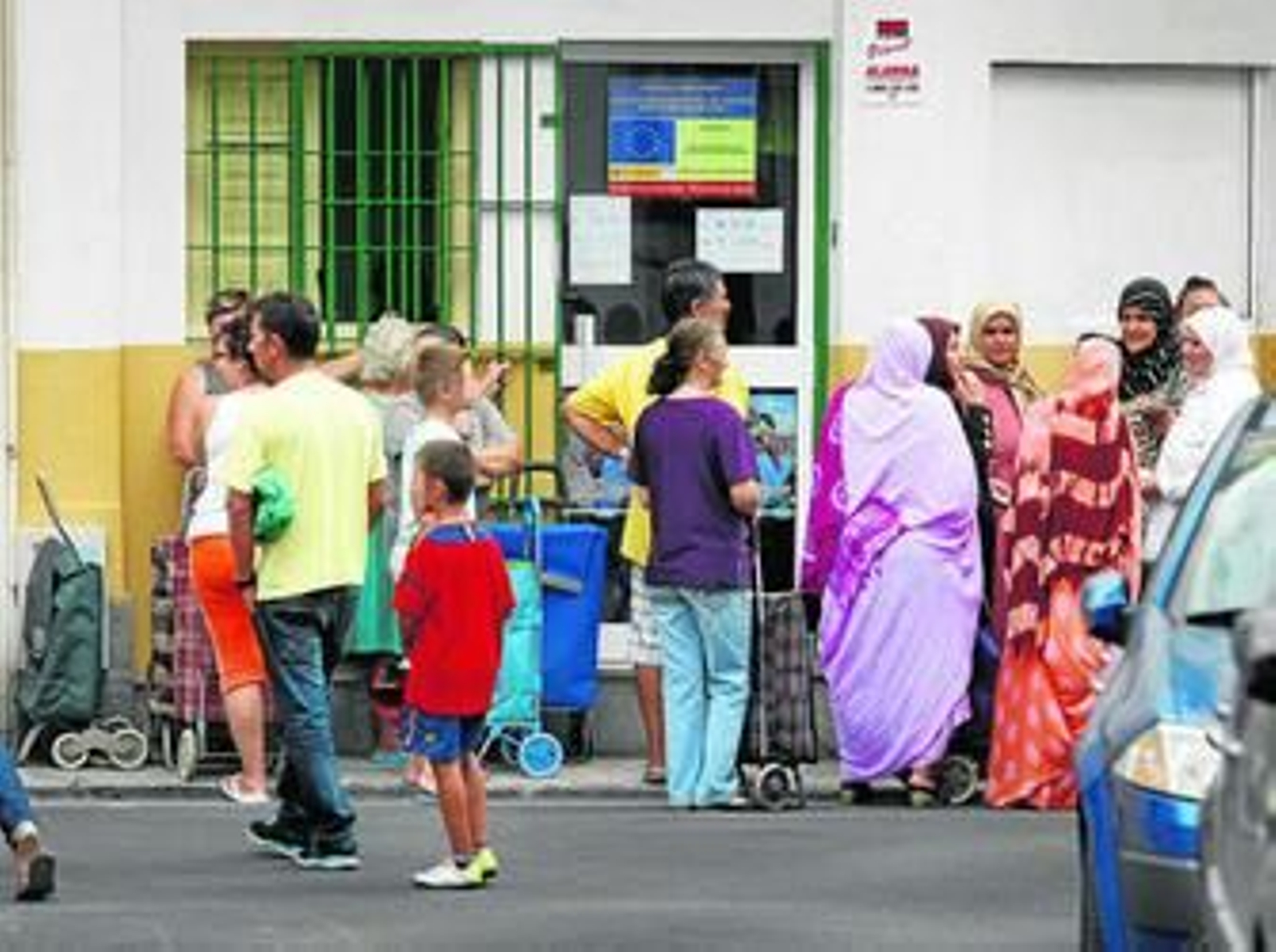 Familias enteras acuden a la sede de Adra, en la calle Diego Niño, para recoger productos básicos de subsistencia.